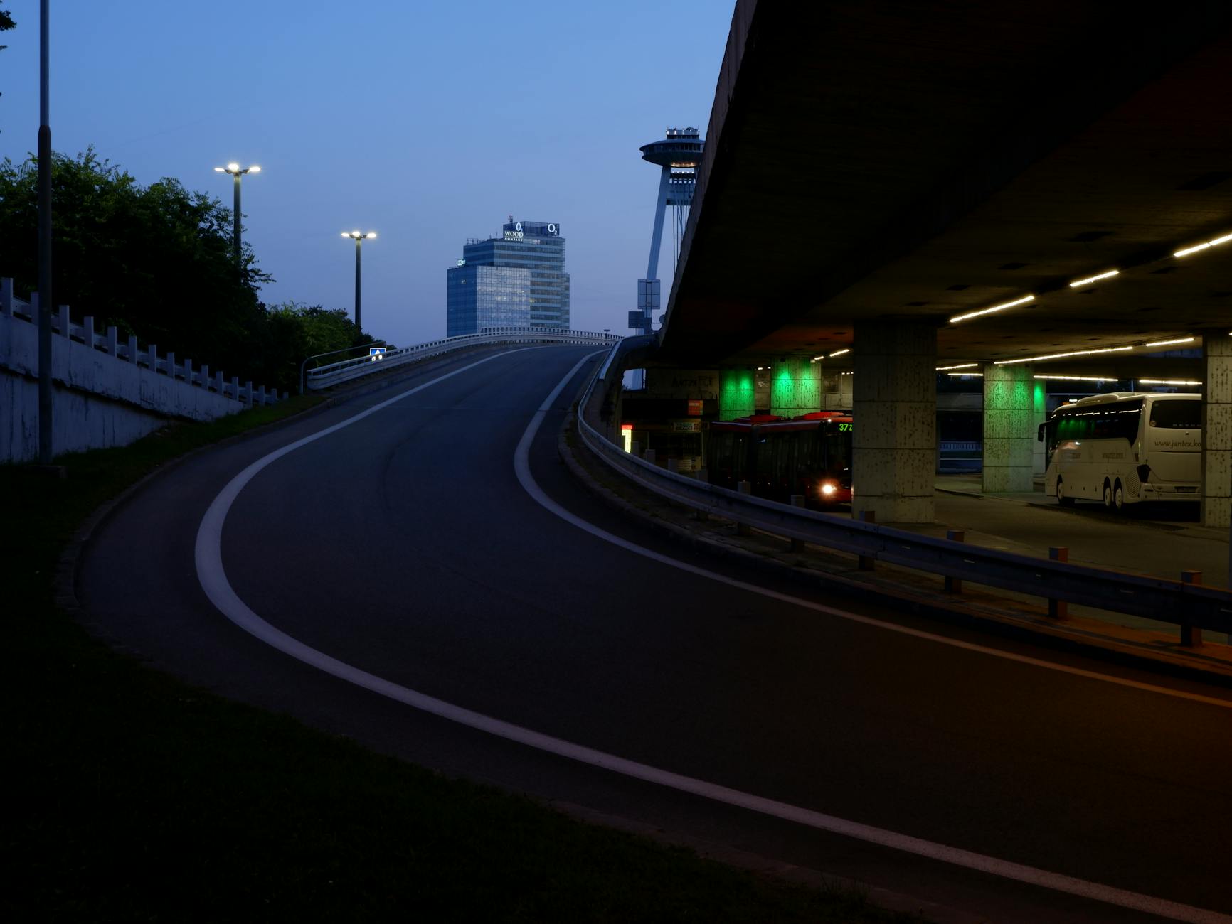 City bus station scene with elevated roads and buses at twilight