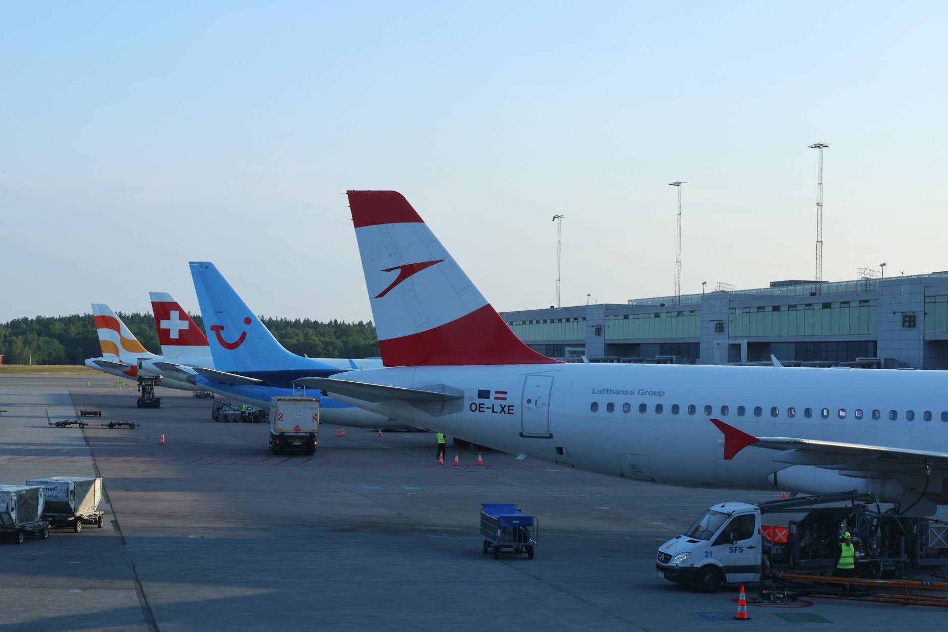 Aircraft lined up at Oslo Airport terminal in daylight