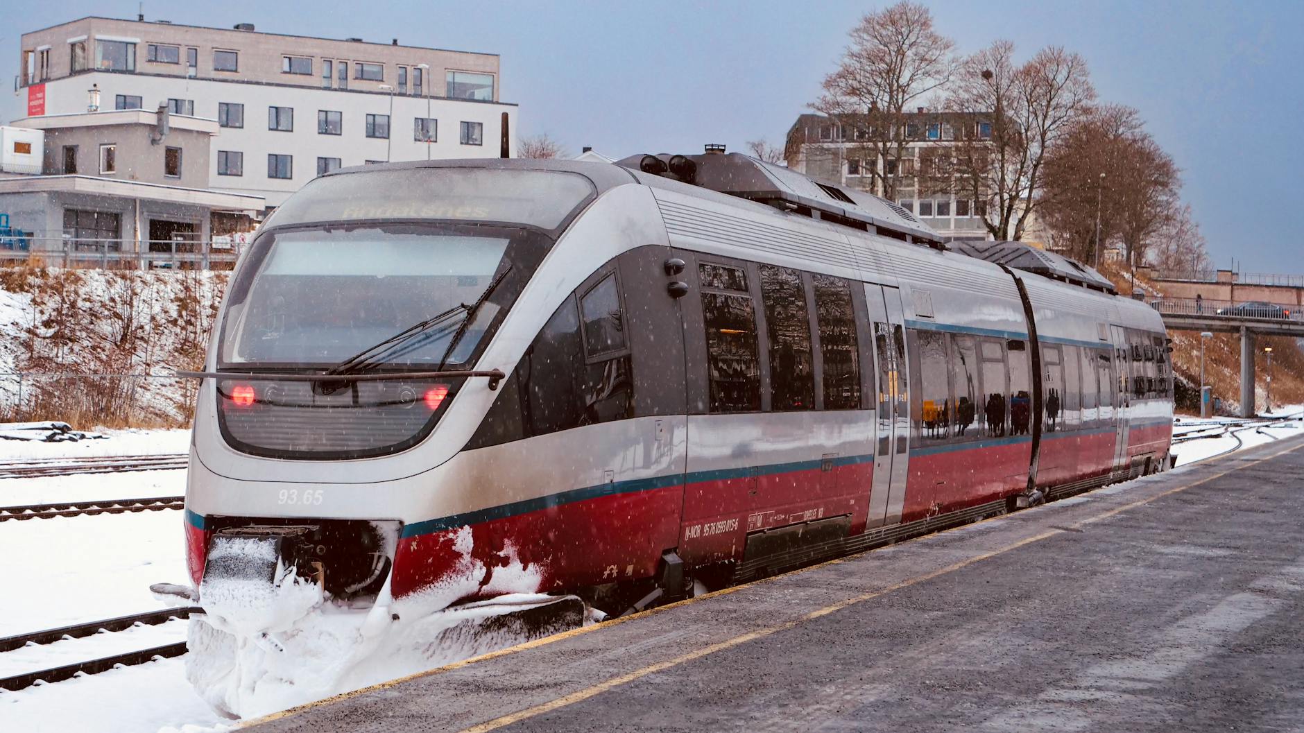 Modern train departing a snowy Norwegian station
