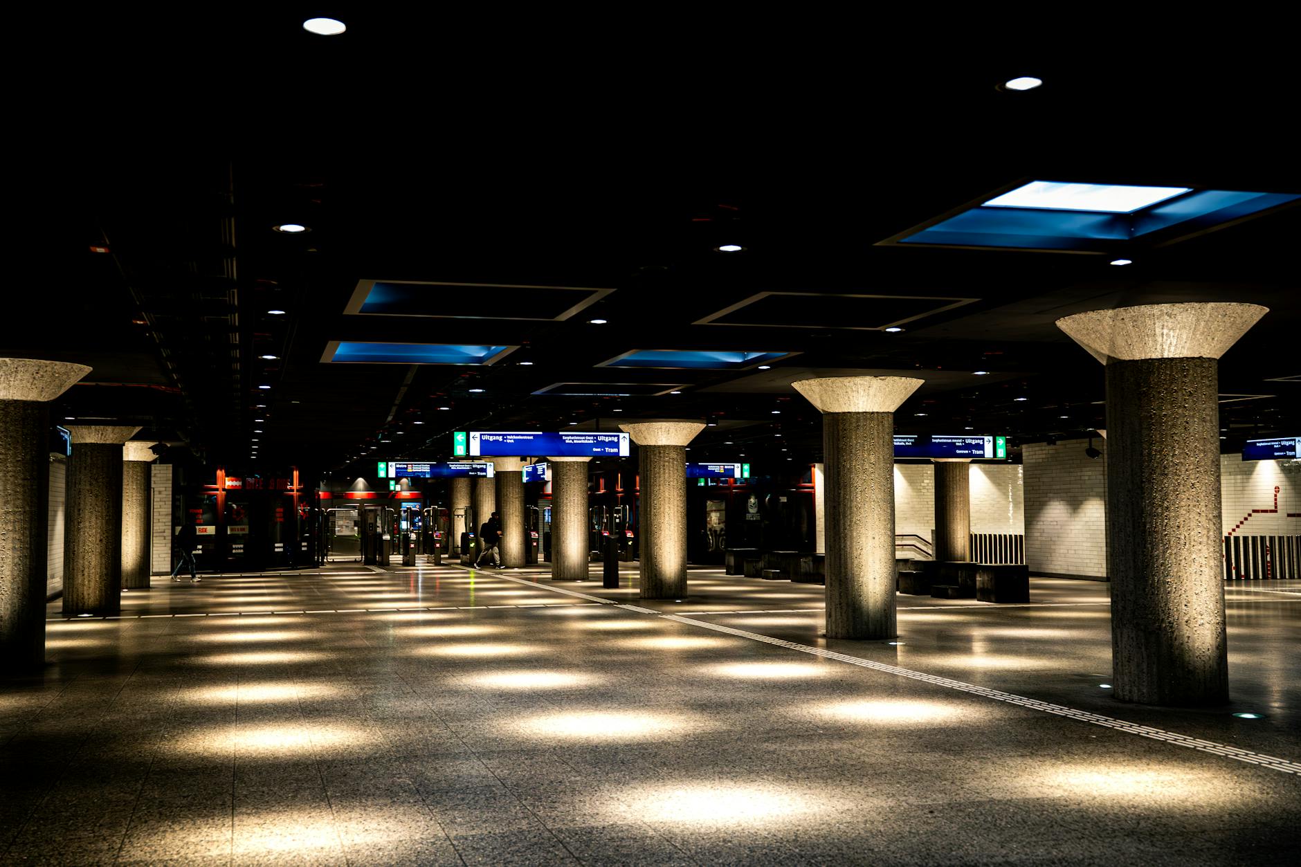 Well-lit urban subway station with concrete columns