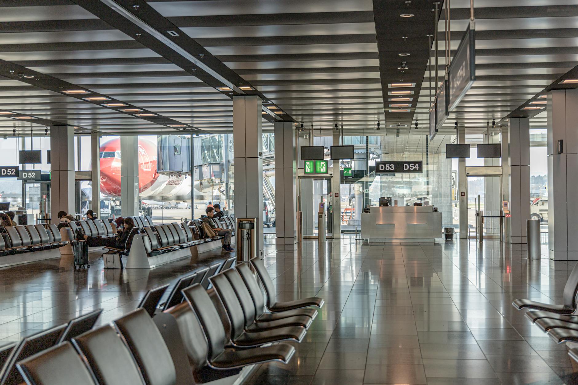 Spacious airport terminal with empty seating and airplane view