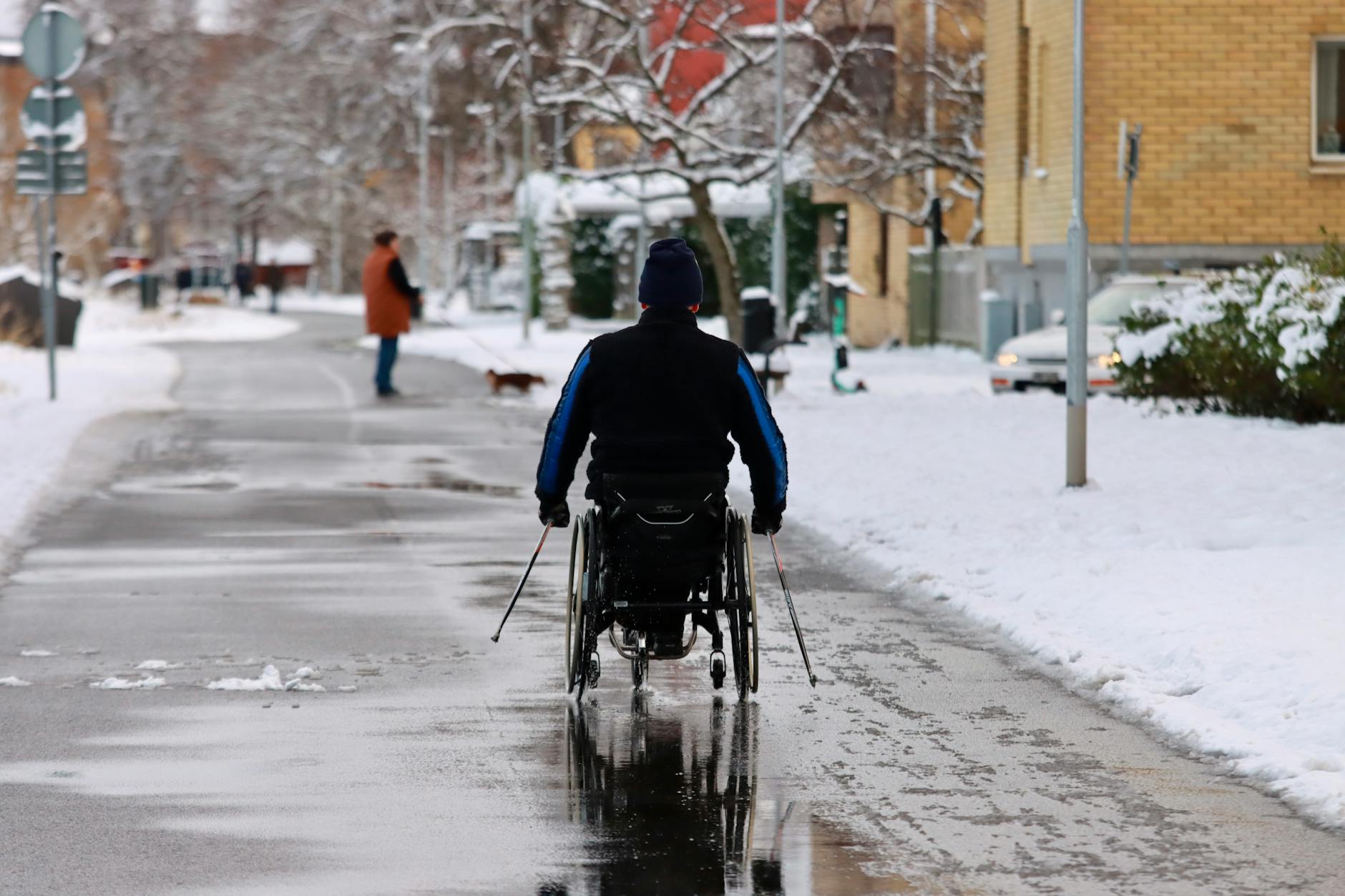 Wheelchair user navigating a snowy winter street