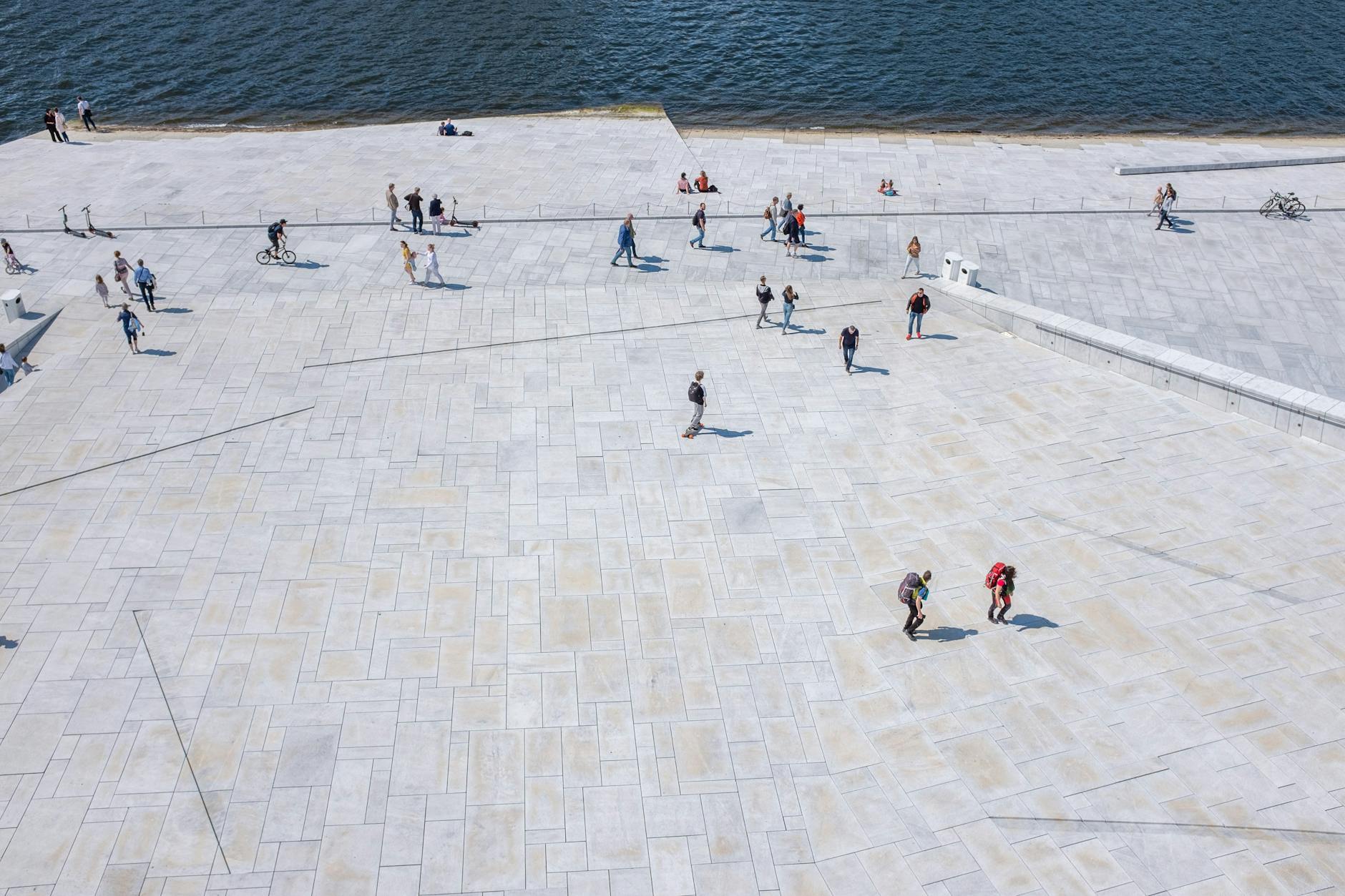 People walking on a broad Oslo waterfront embankment