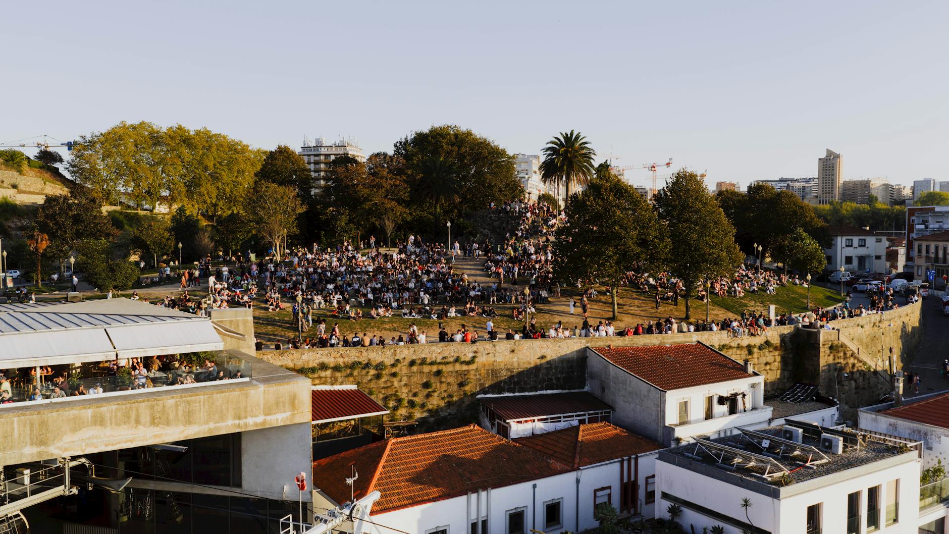 Crowd gathered in a Porto park at sunset