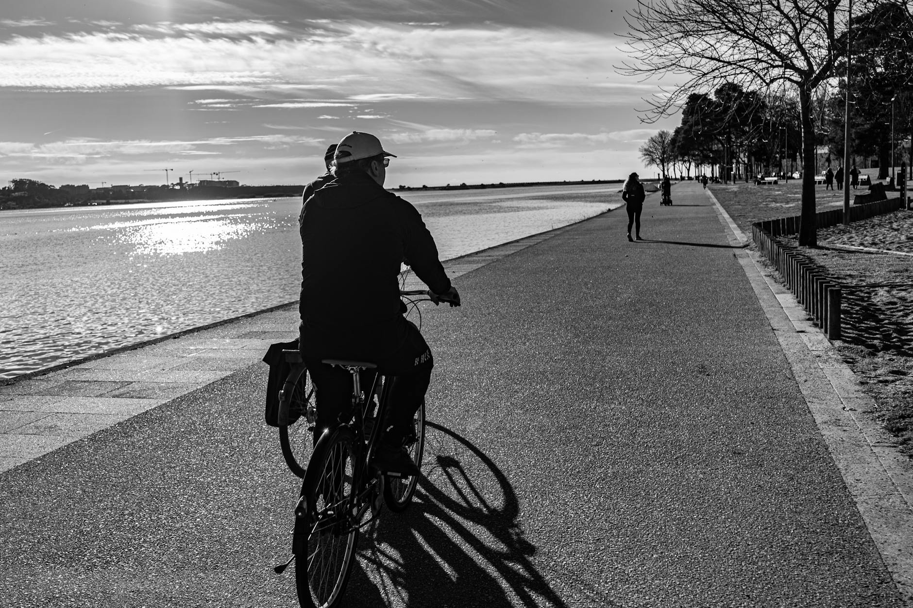 Cyclist riding along a river promenade in Porto