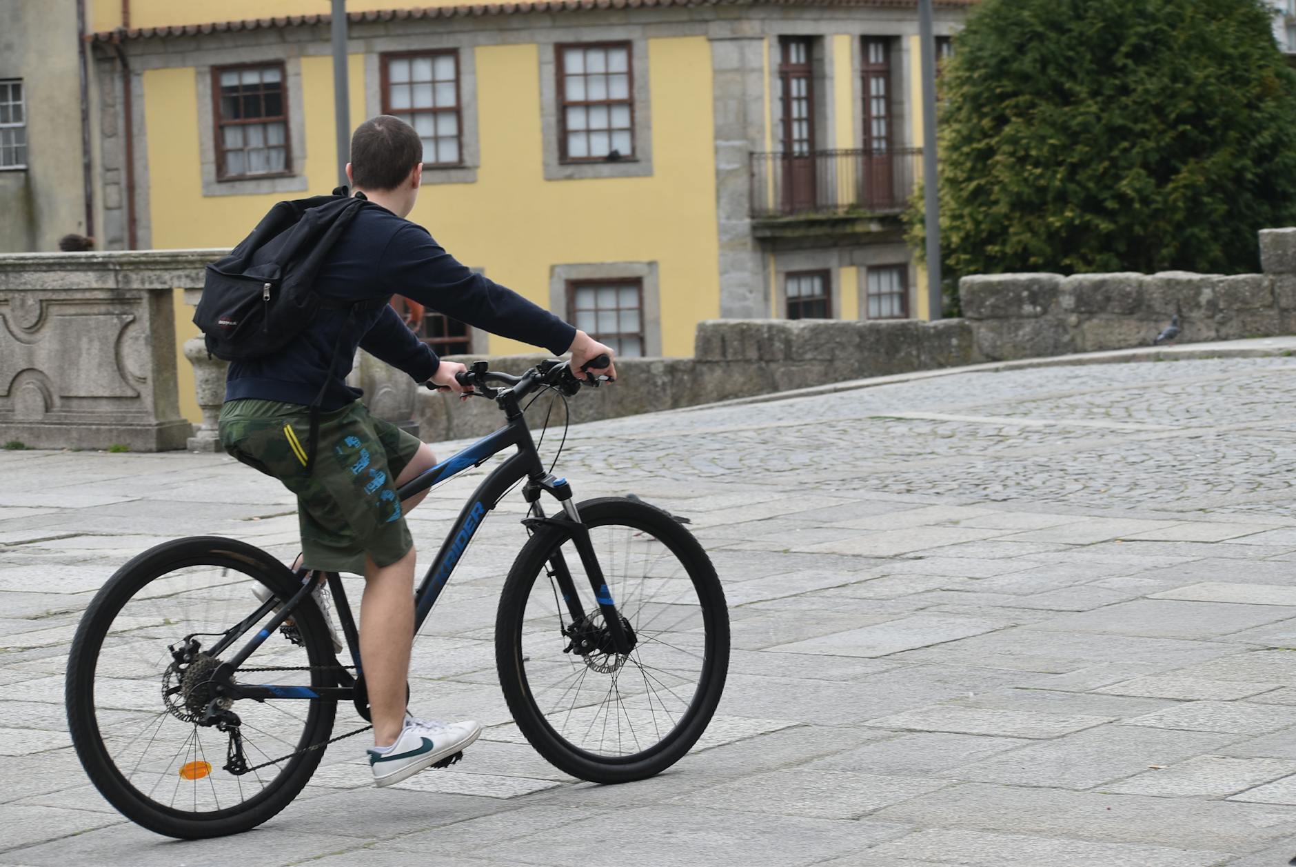 Cyclist riding through cobblestone streets in Porto