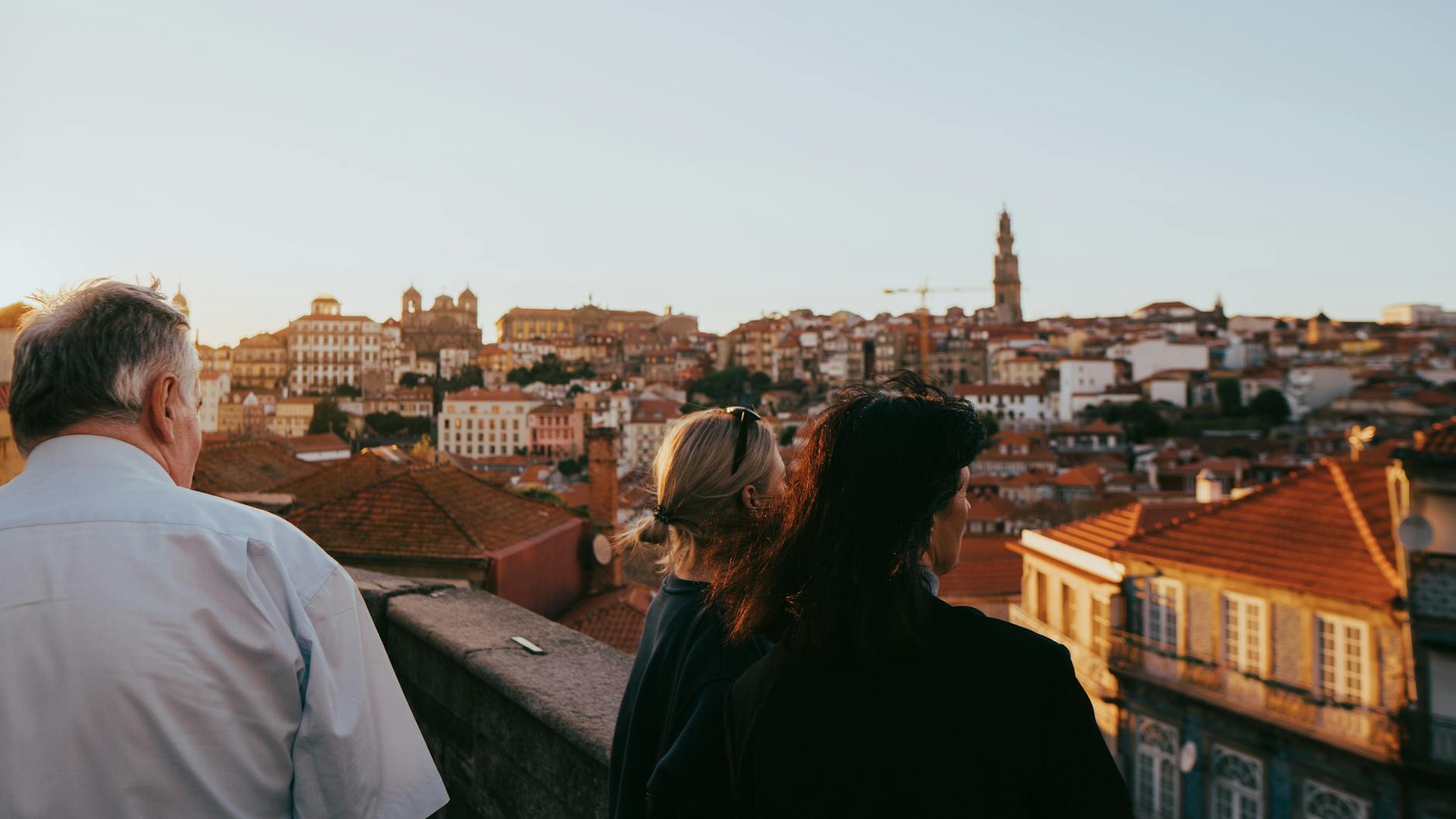 Tourists overlooking Porto rooftops at sunset