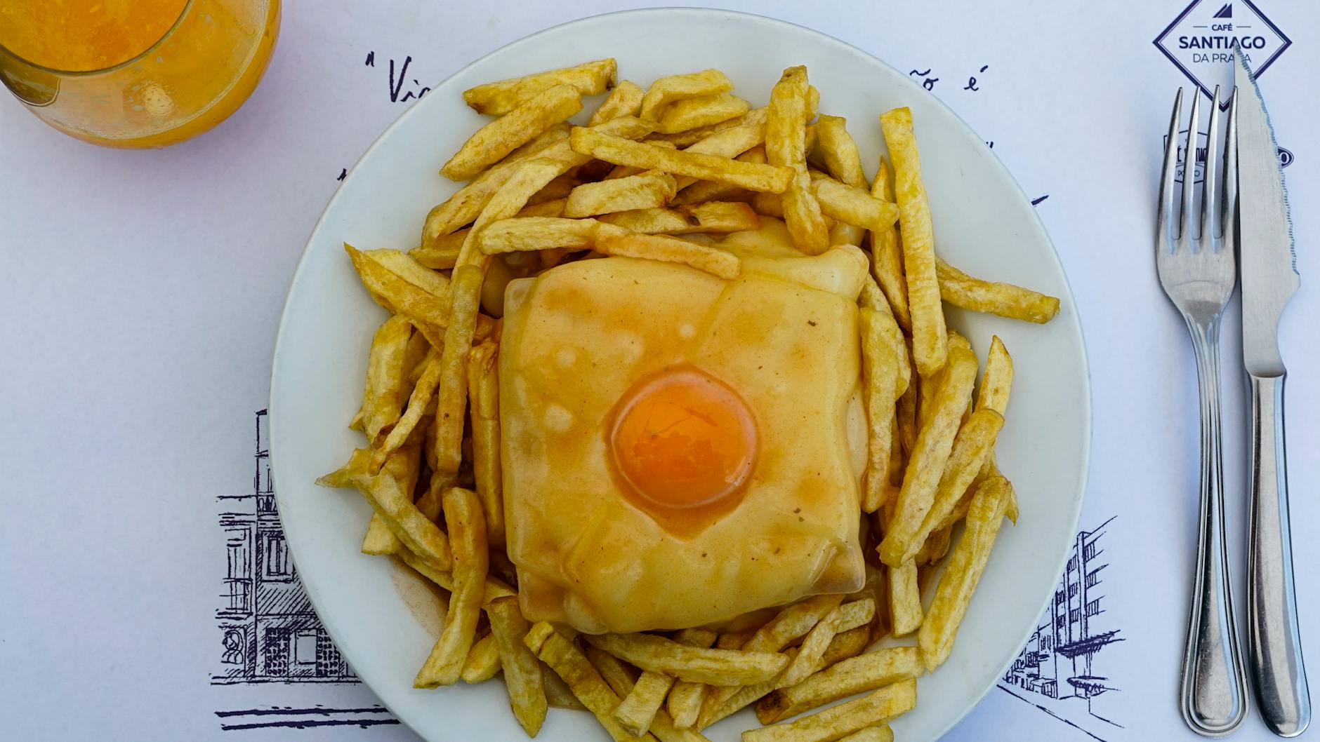 Francesinha sandwich with fries and juice