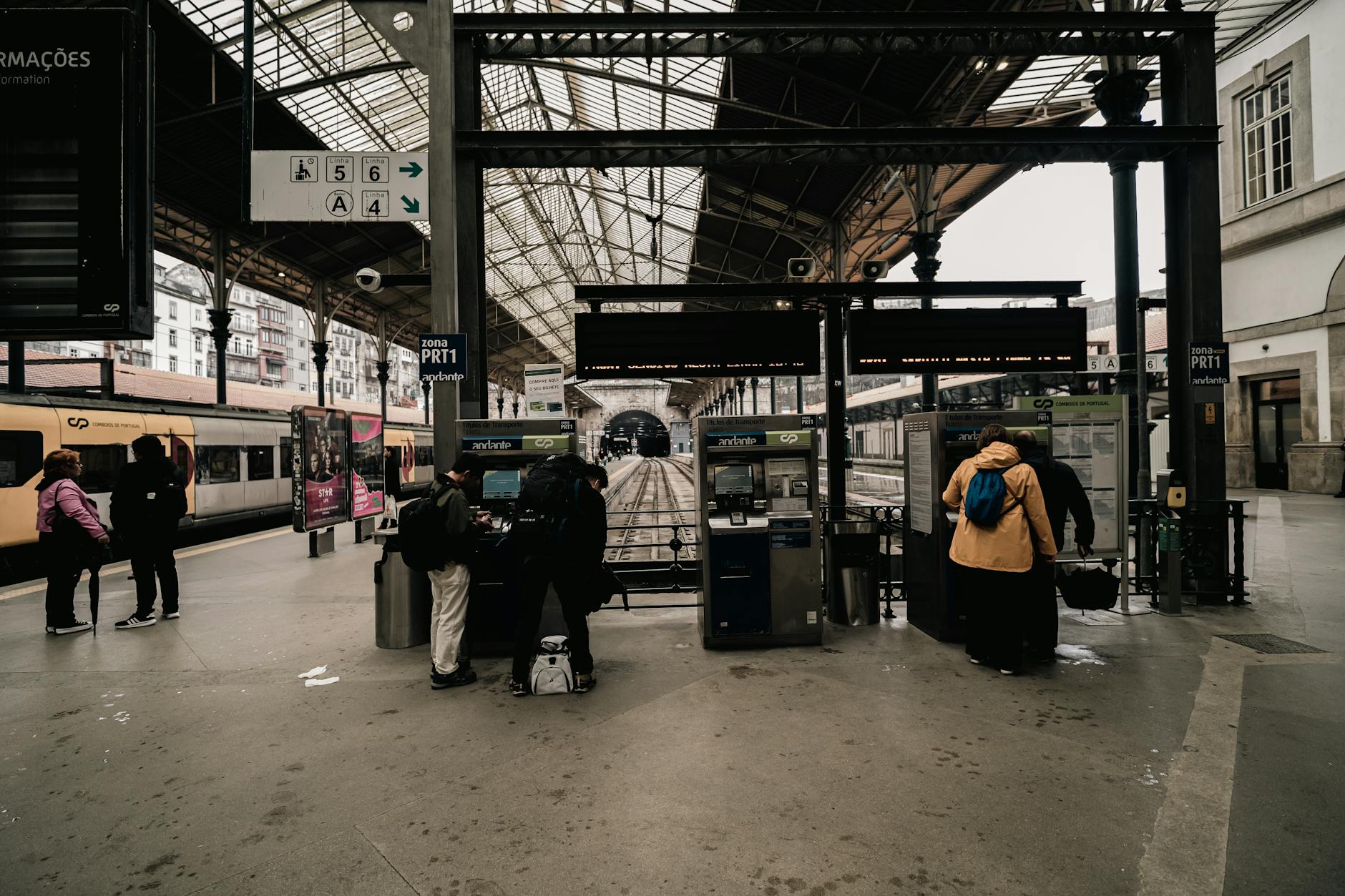 Travelers at ticket machines inside Sao Bento Railway Station in Porto