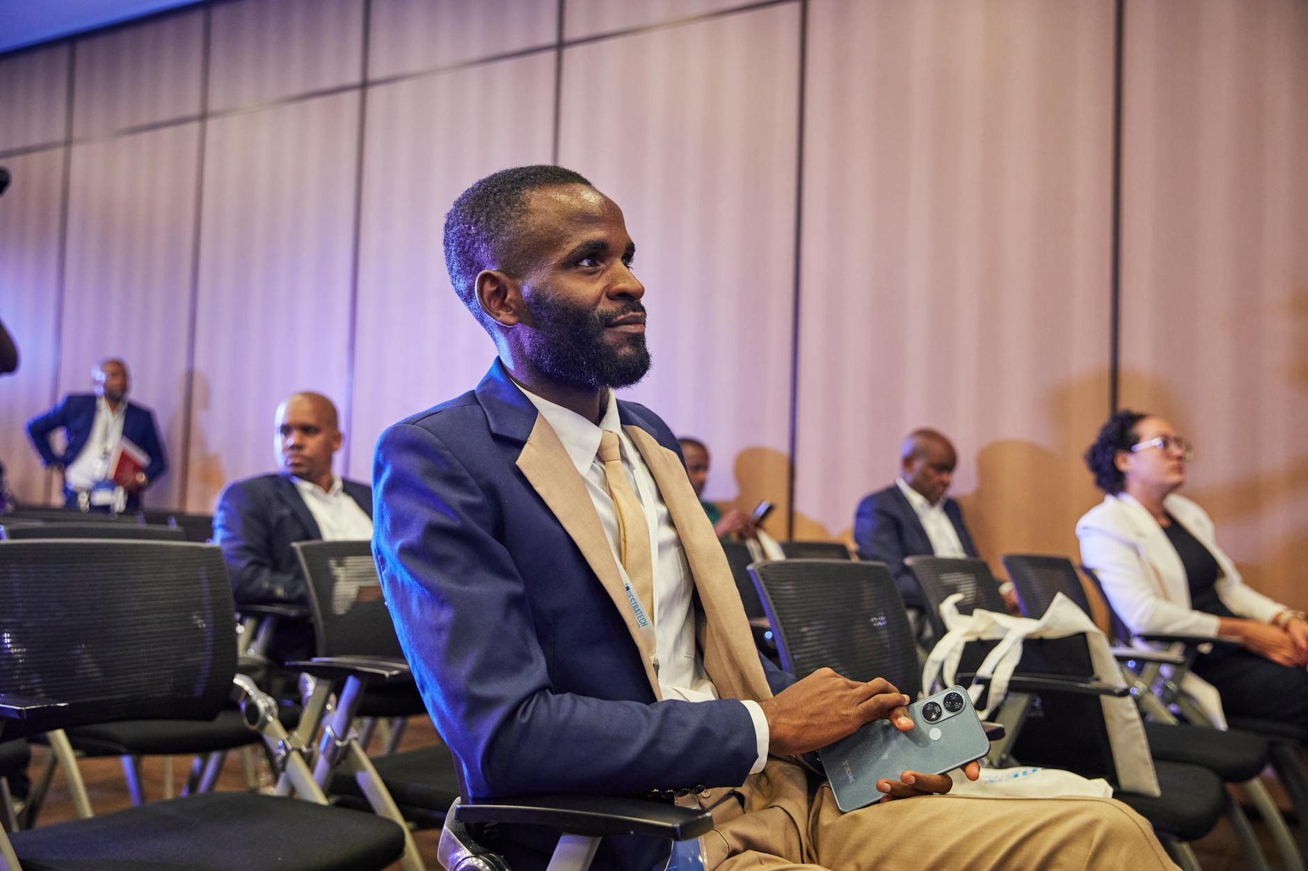 Business professional attending a conference while holding a phone
