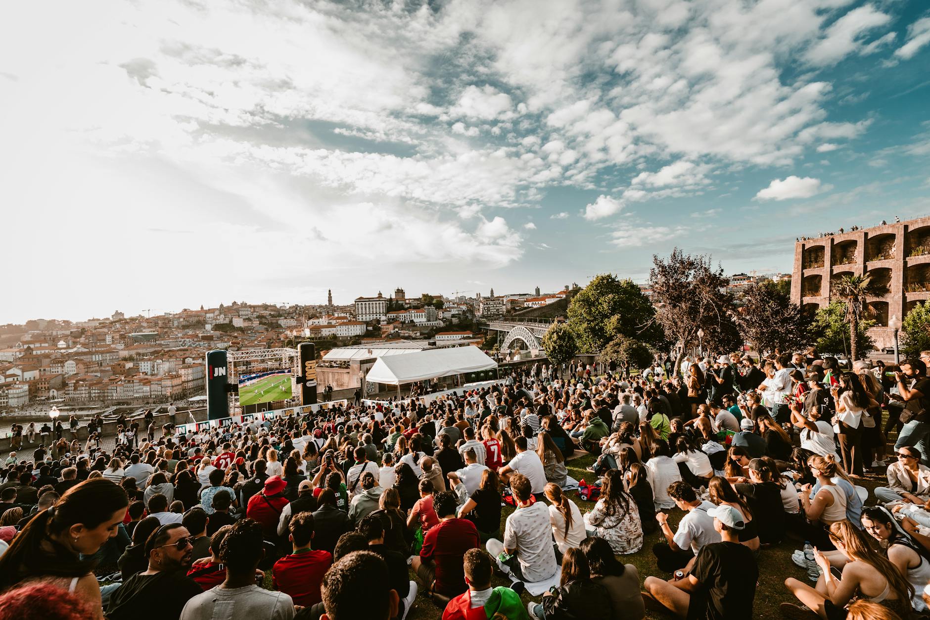 Large crowd gathered in Porto with cityscape behind them