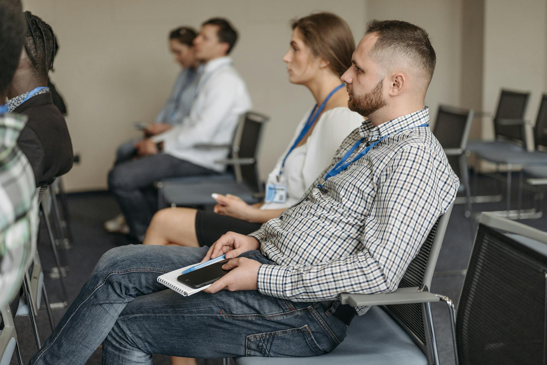 Adults attending a business seminar with notebooks and phones