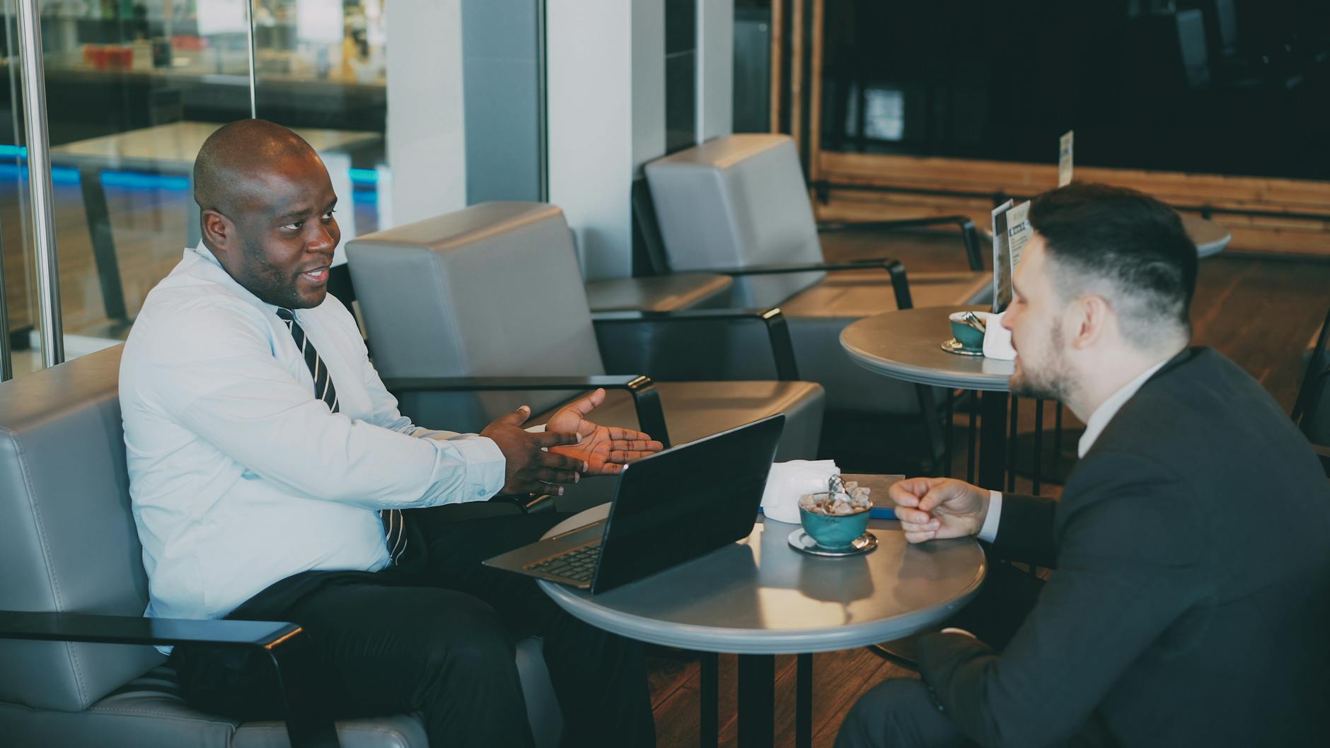 Businessmen discussing work over coffee in a modern cafe