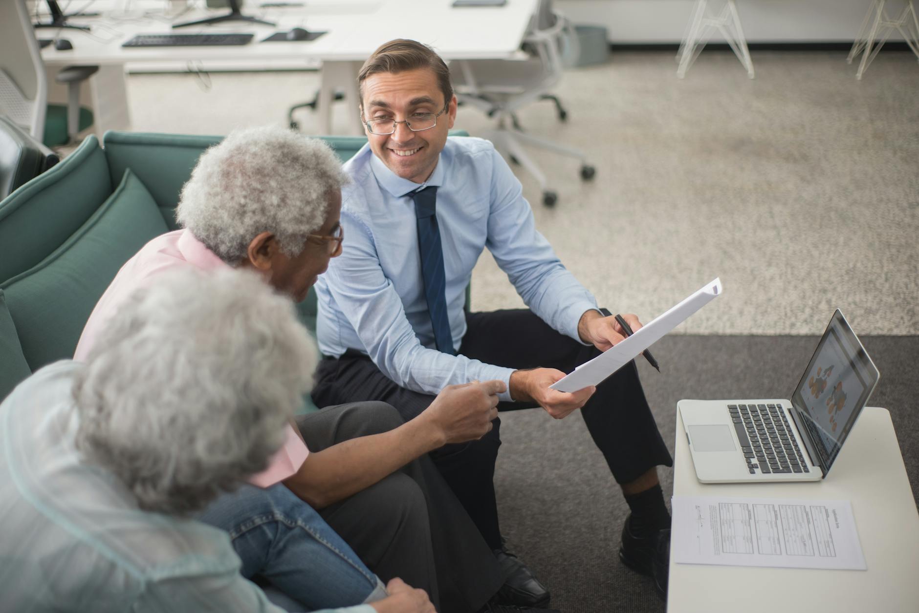Consultant discussing documents and laptop with clients