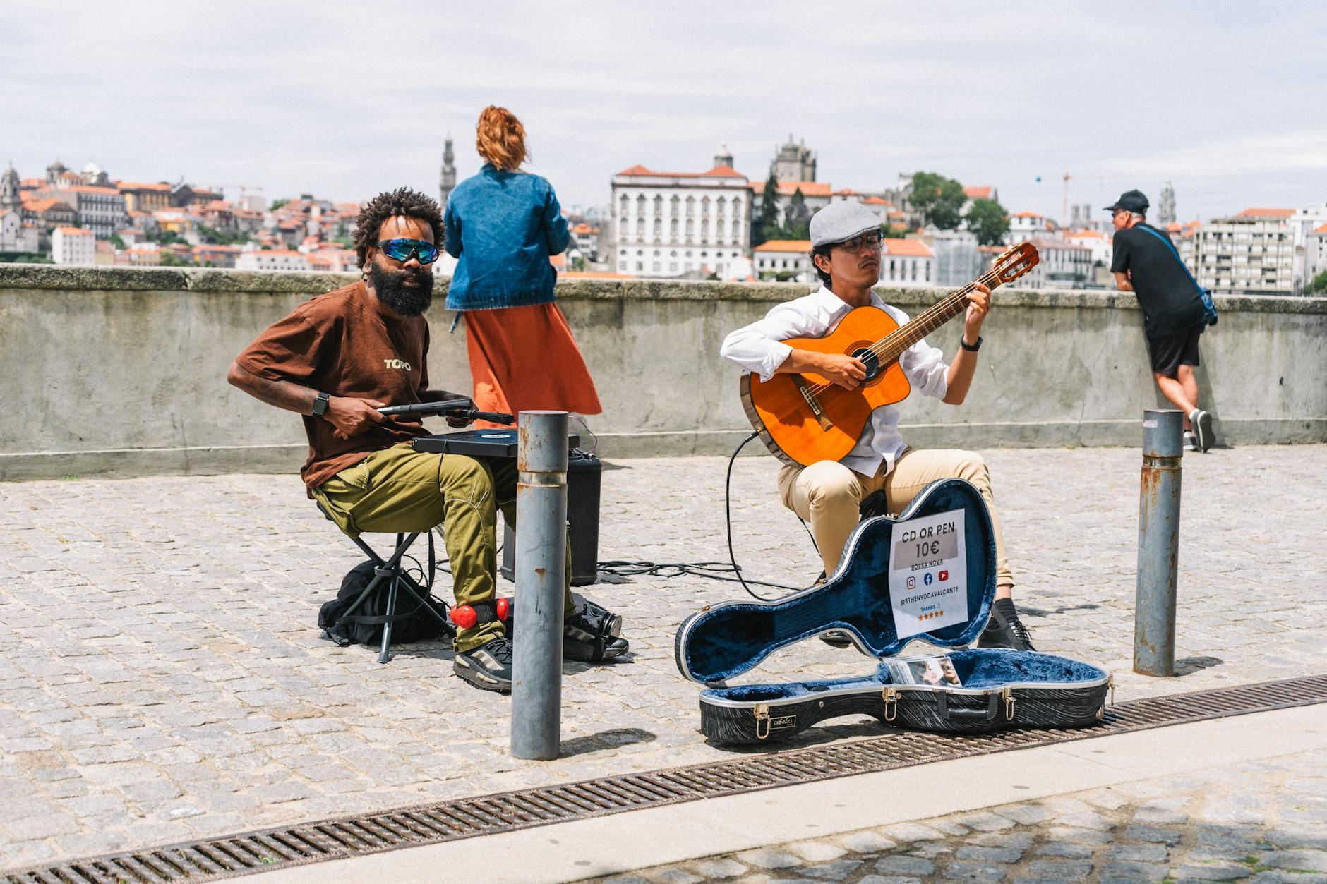 Musicians busking in Porto with cityscape behind them