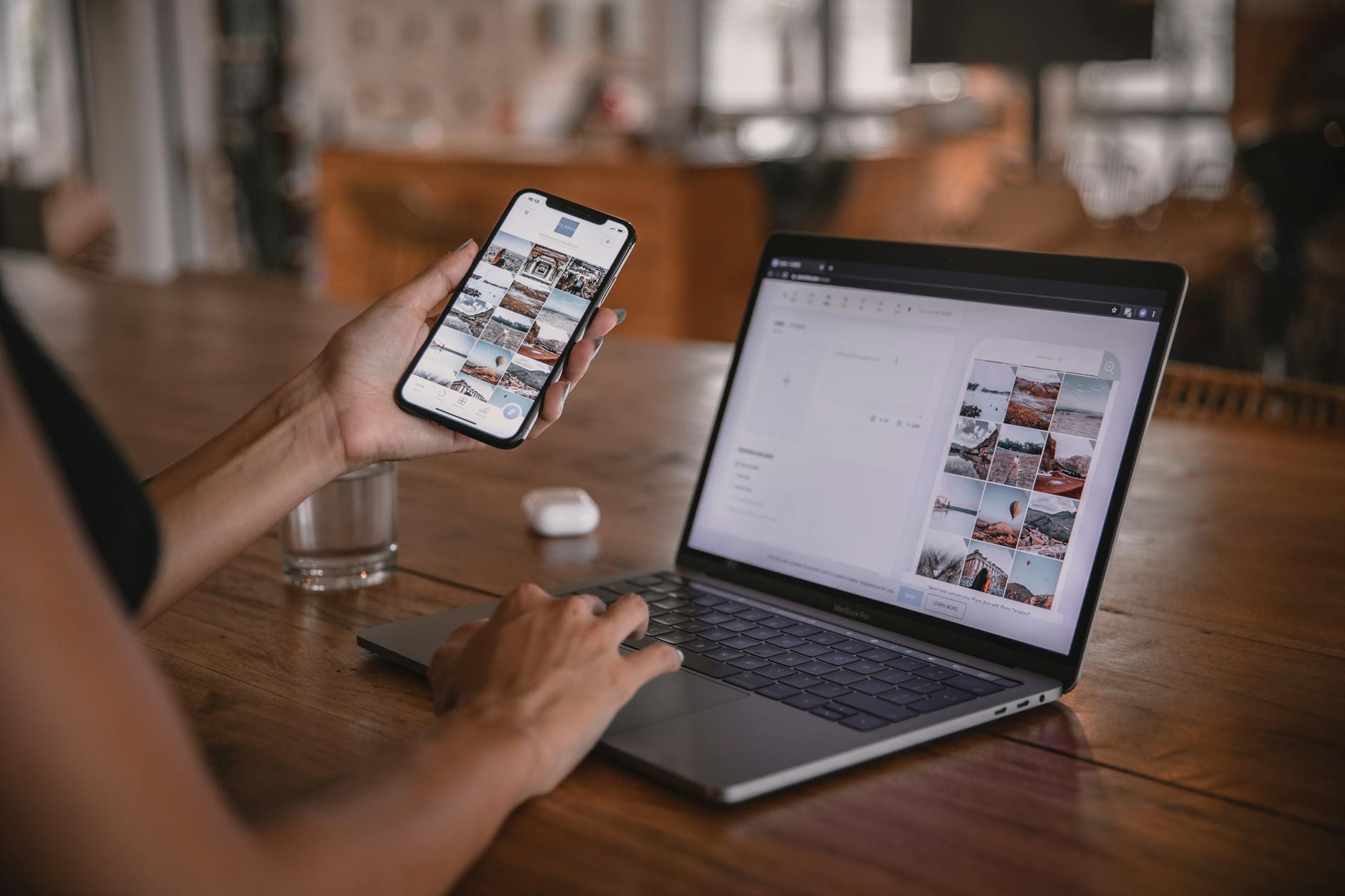 Creator editing social media content on phone and laptop at a cafe