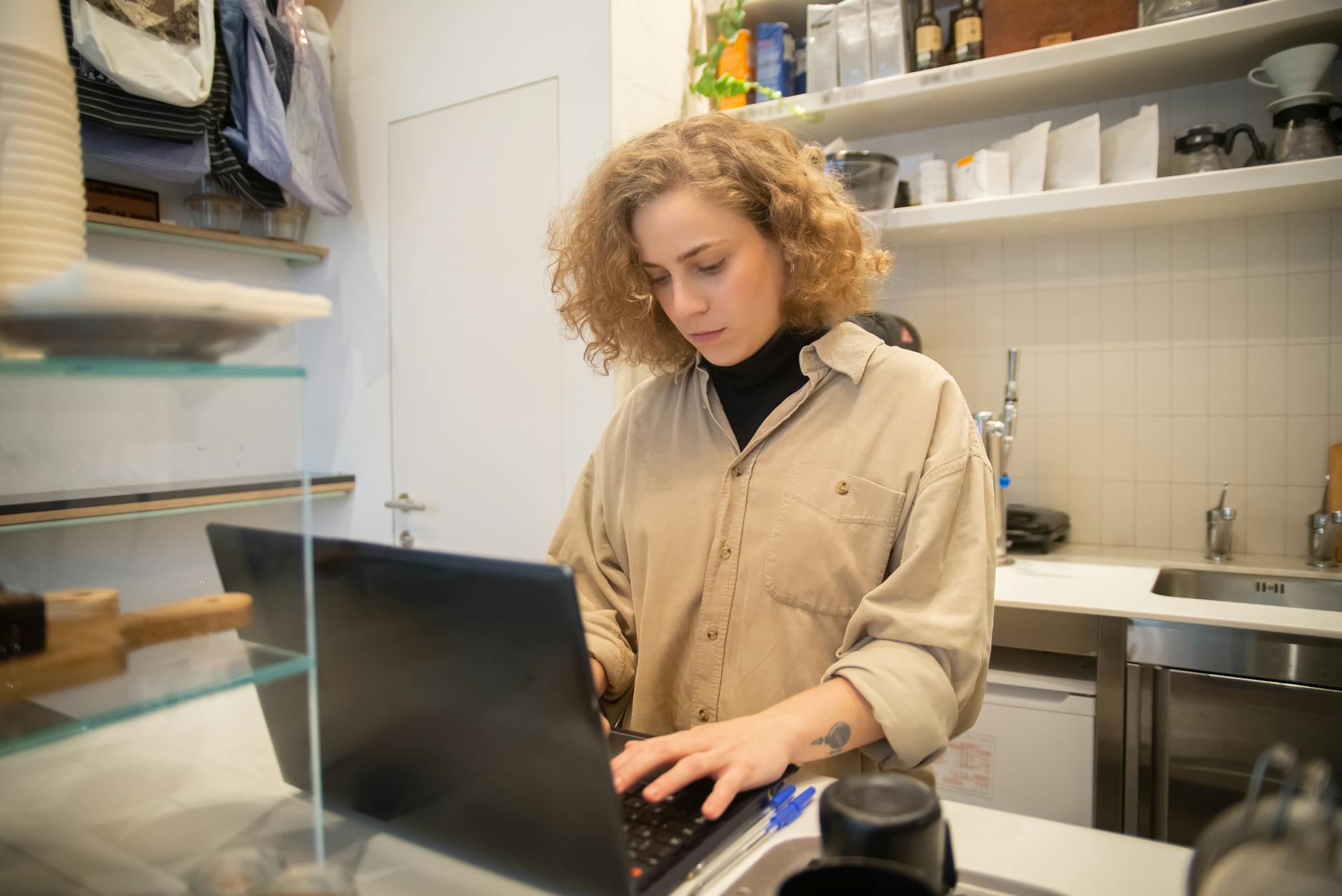Woman typing on a laptop in a boutique cafe