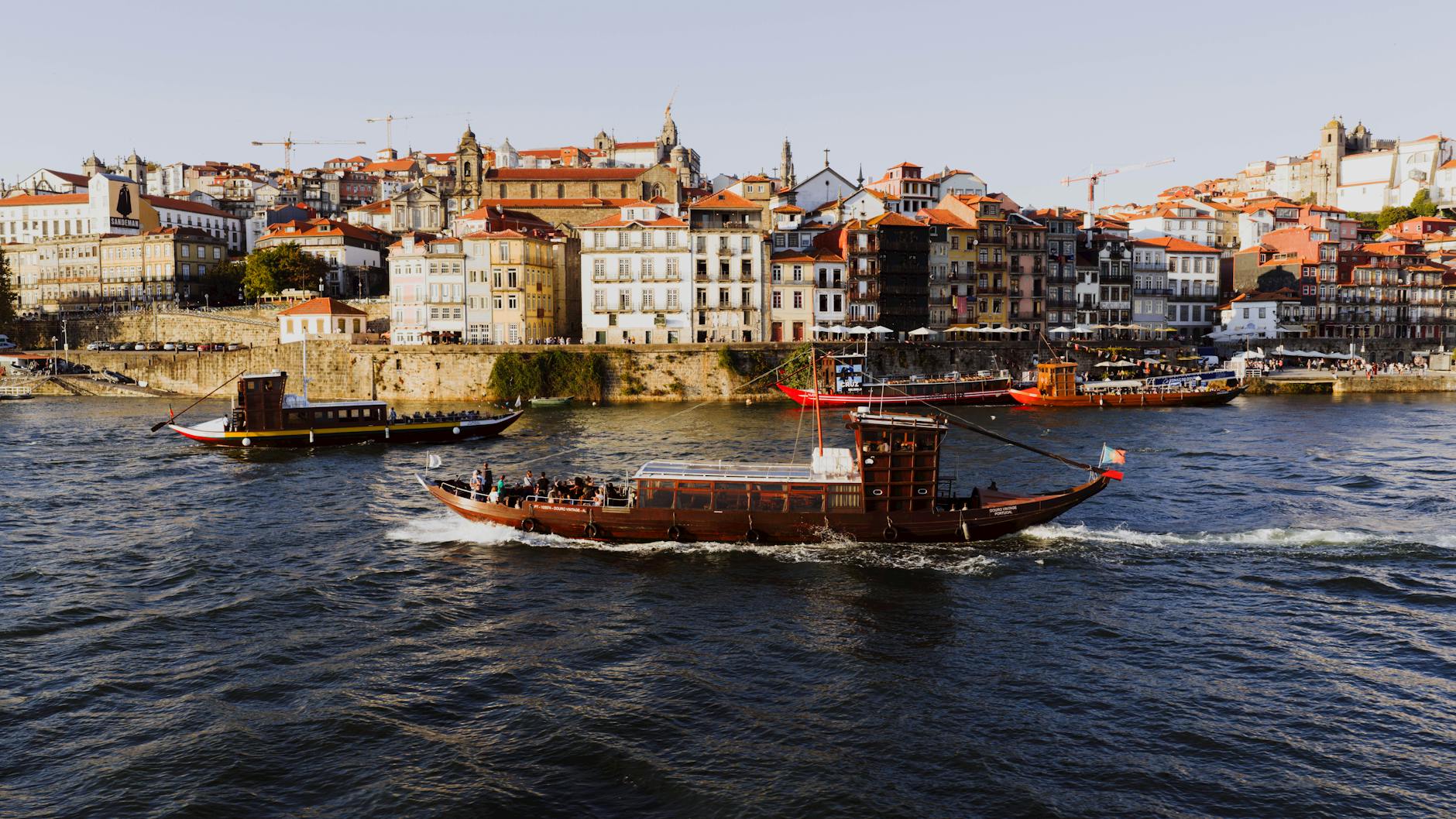Boats sailing on the Douro River at sunset in Porto