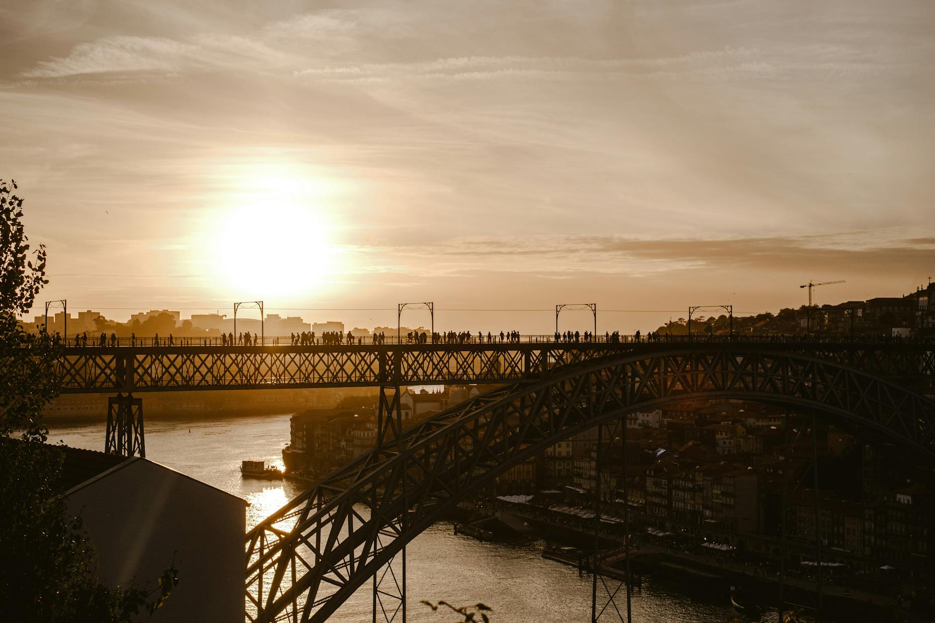 People silhouetted on the Dom Luis I Bridge at sunset