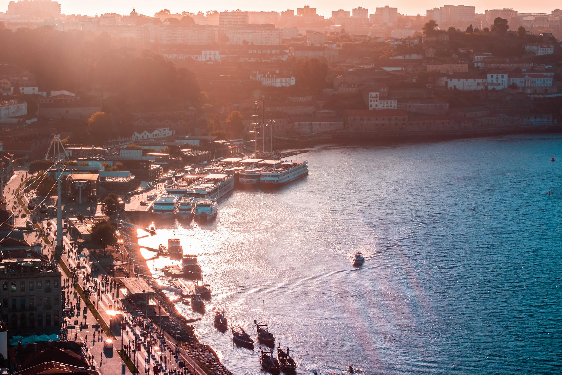 Sunset over Porto harbor with boats and cityscape