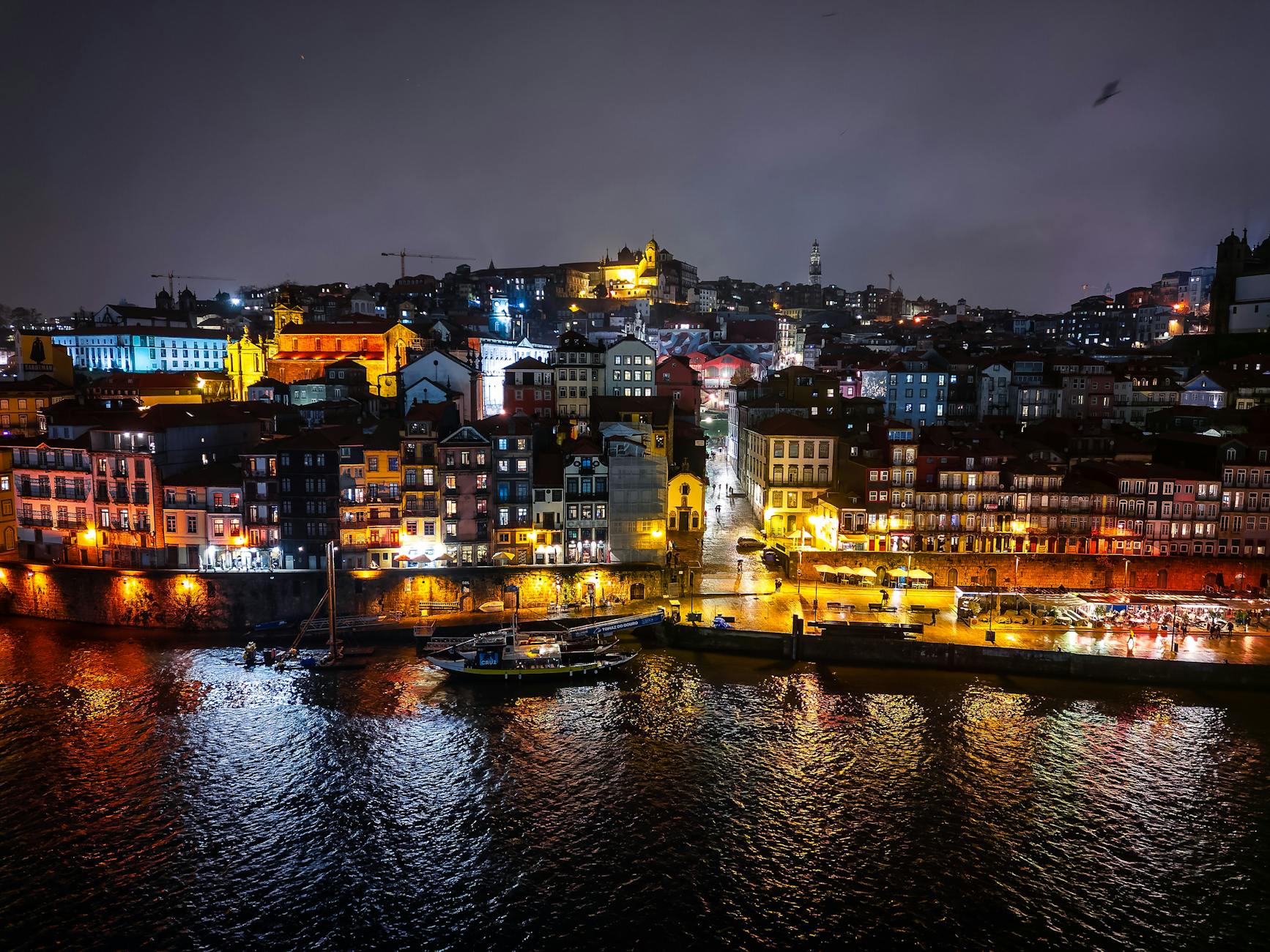 Illuminated Porto waterfront buildings reflected in the Douro River