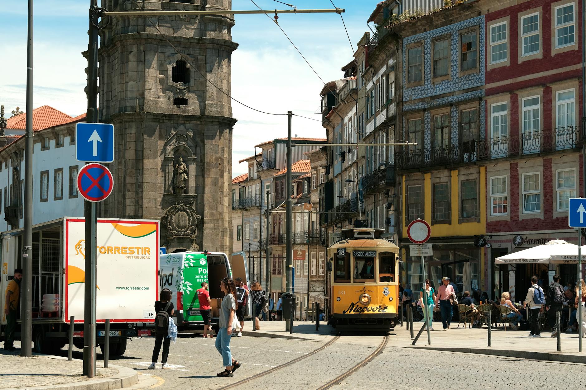 Lively Porto street with tram and Clerigos Tower in the background