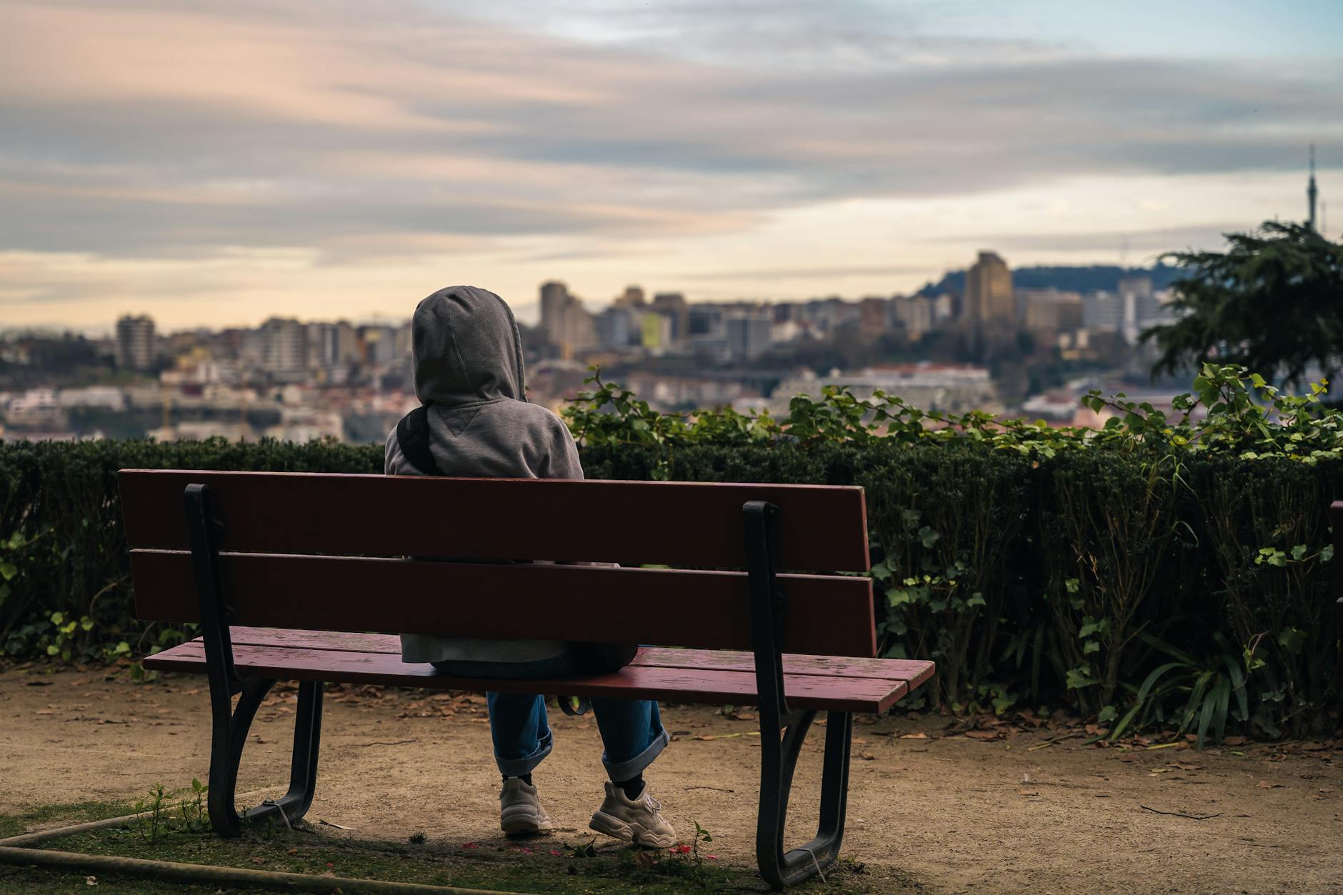 Person sitting on a bench and looking at Porto at sunset