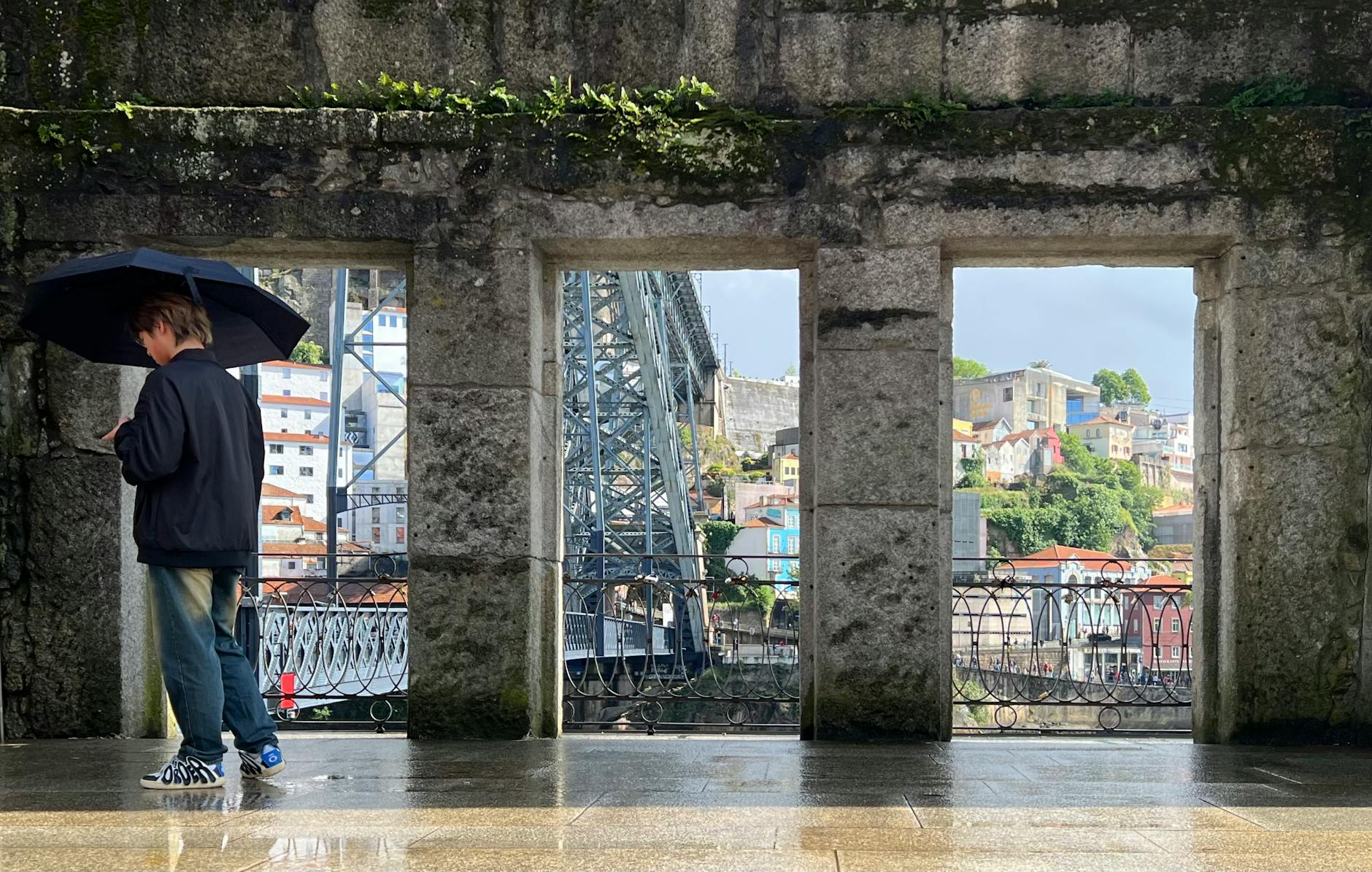 Person with an umbrella near the Dom Luis I Bridge in Porto