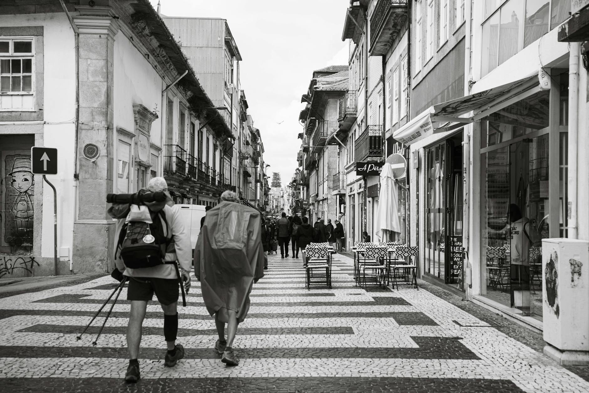 Backpackers walking along a charming Porto street
