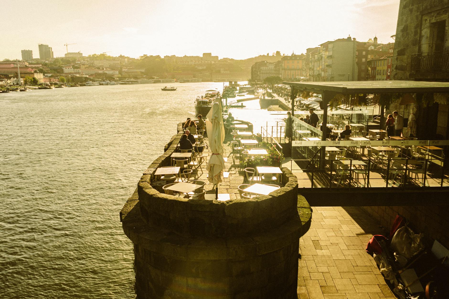 Warm sunset over Porto riverside cafes and promenade