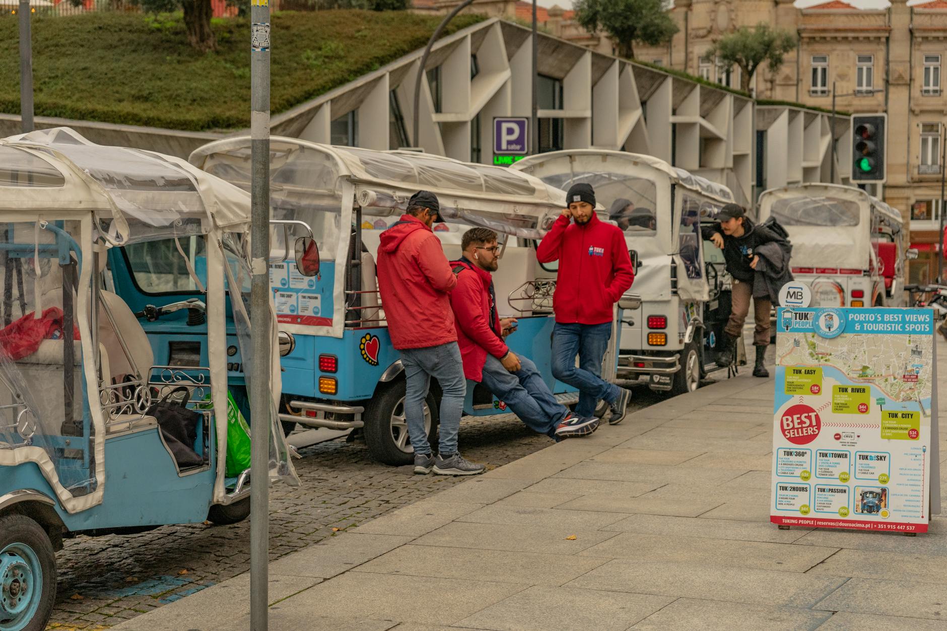 Tourists gathered around tuk tuks in Porto