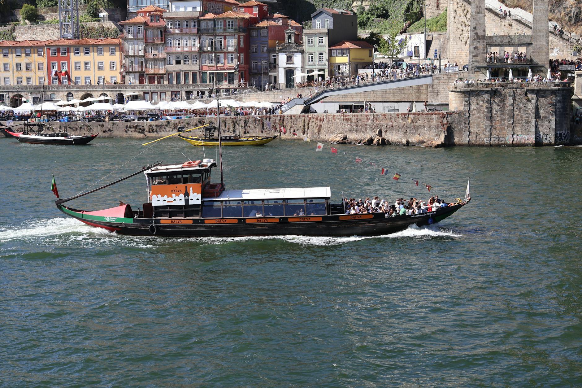 Traditional boat on the Douro River with Porto buildings behind it
