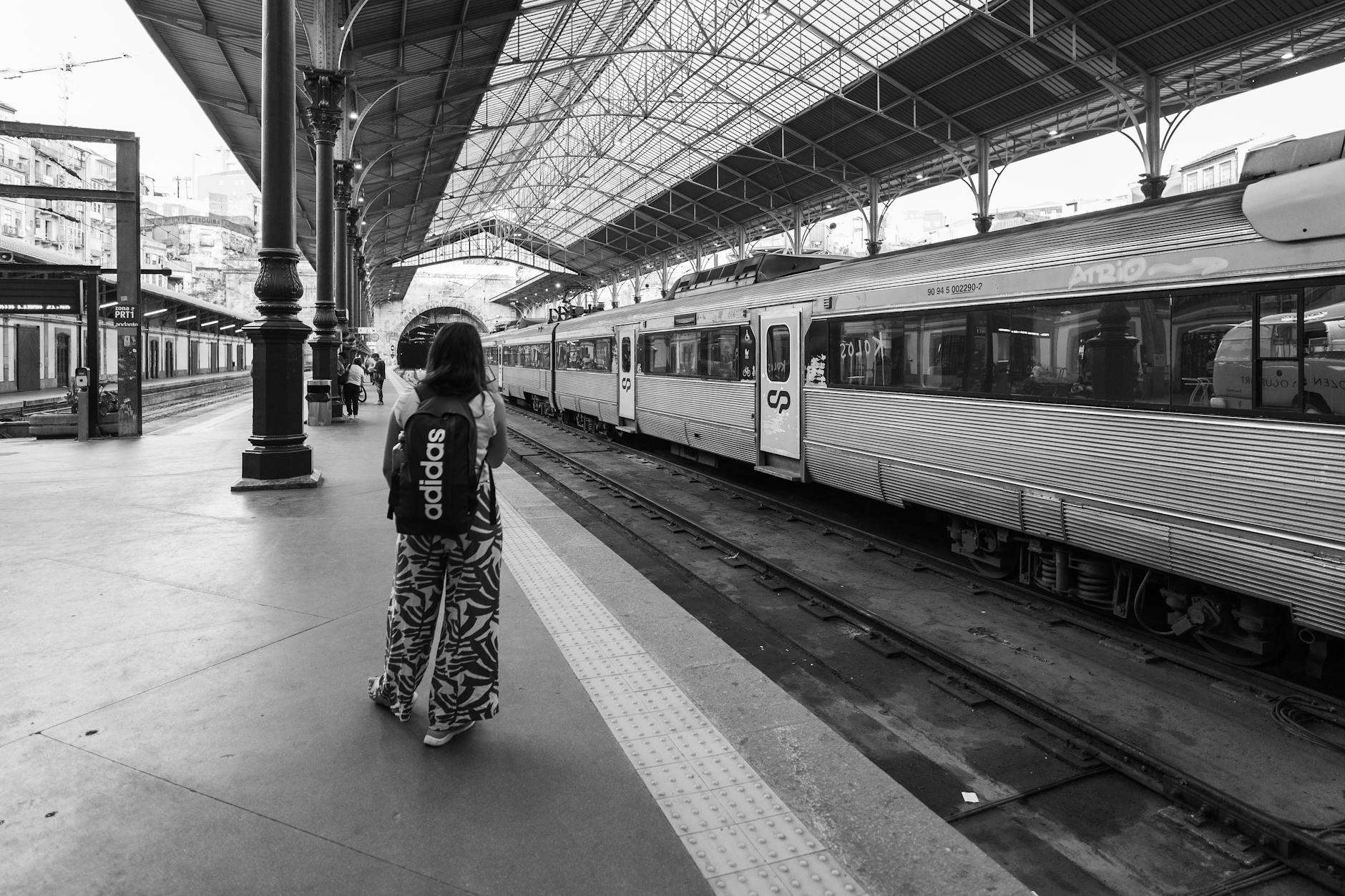 Person waiting at a train station platform in Porto