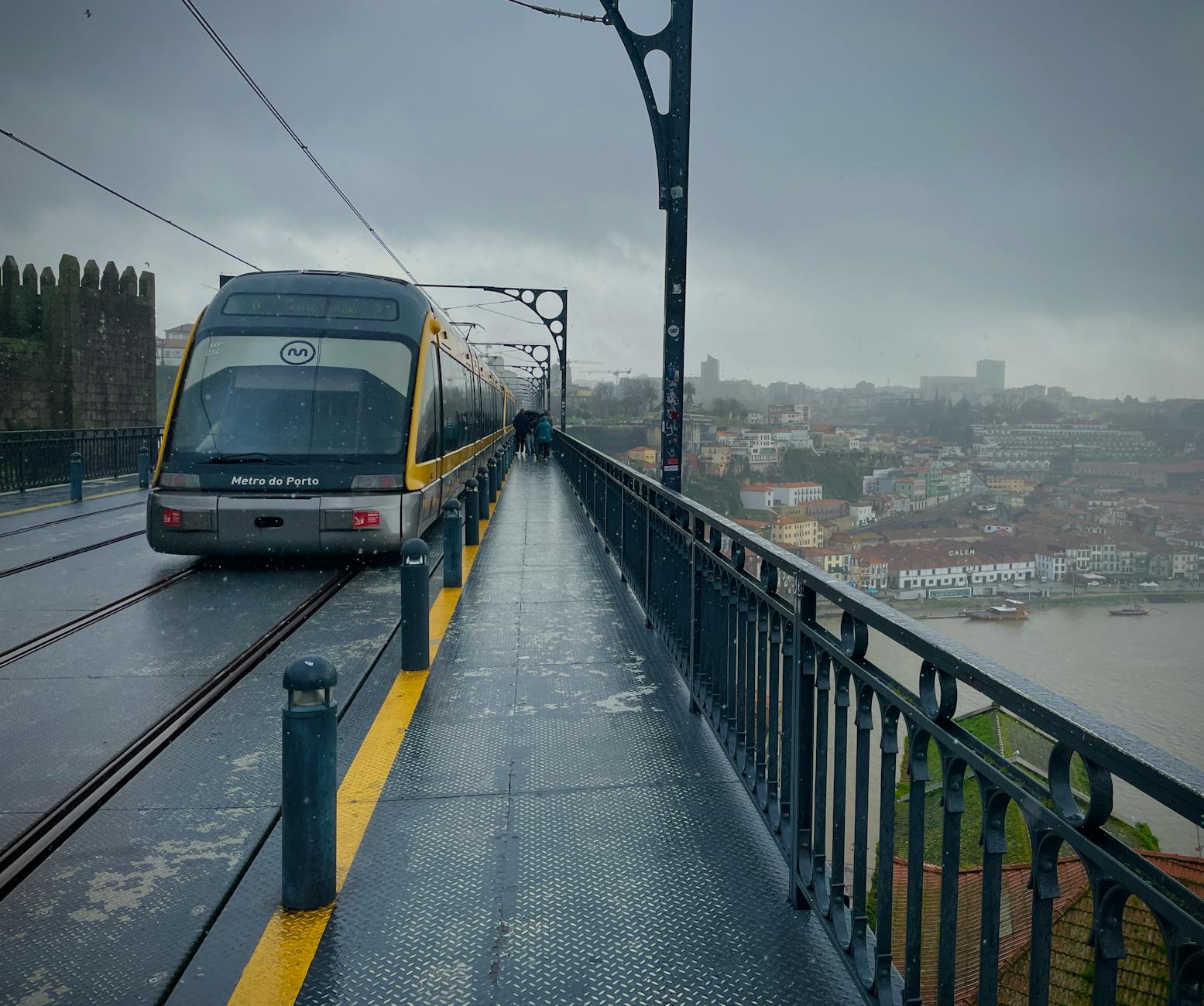 Tram crossing the Luis I Bridge in Porto on a rainy day