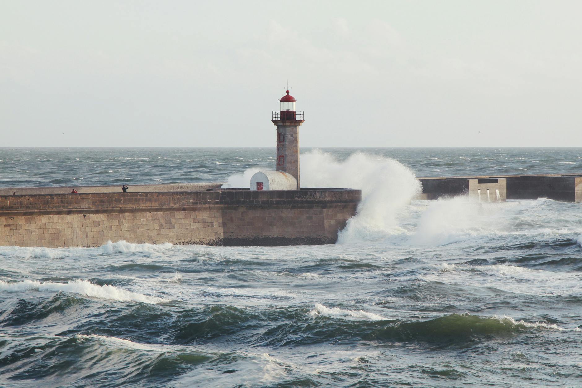 Lighthouse on Porto's coastline with waves crashing