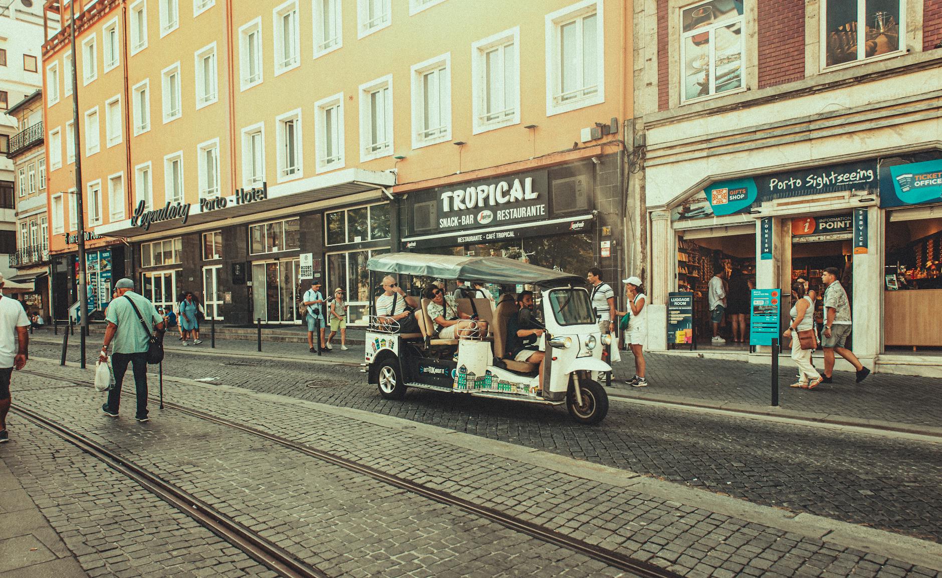 Tuk-tuk and pedestrians on a Porto street