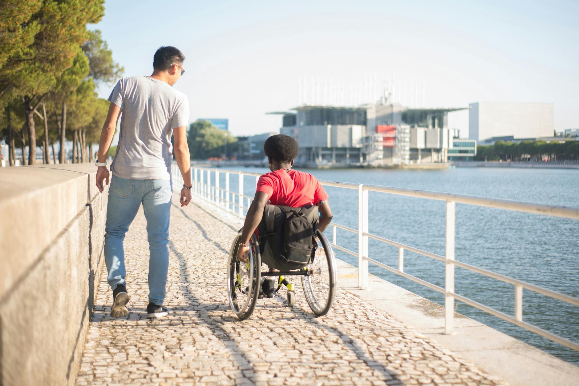 Traveler using a wheelchair beside a riverside path in Portugal