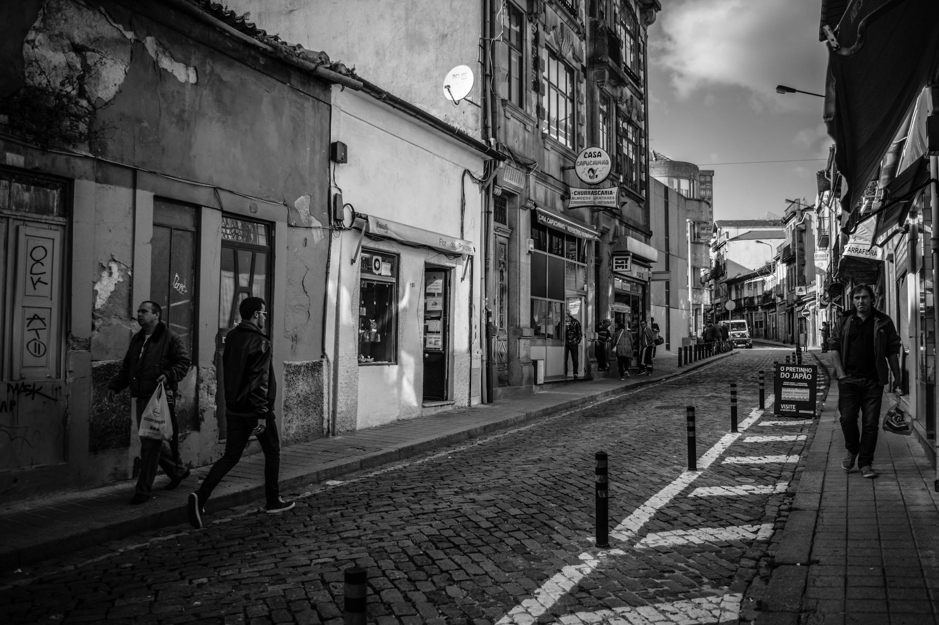 Black and white Porto street scene with people and shops