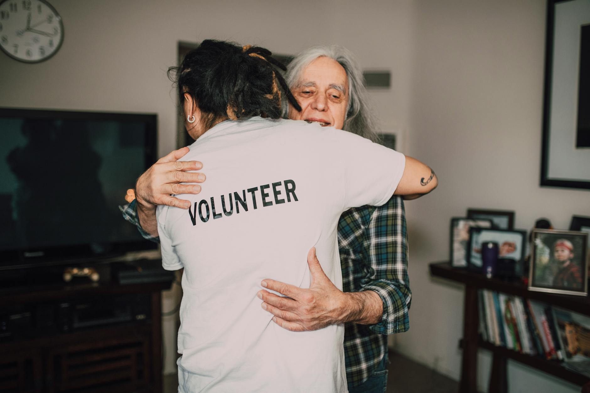 Volunteer embracing a senior woman during a support visit