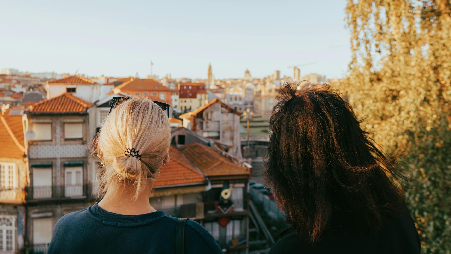 Two women looking over the Porto cityscape at sunset