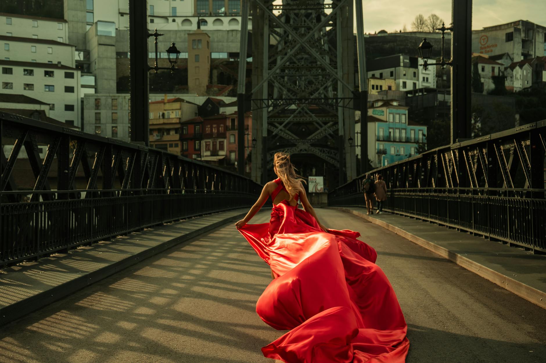 Woman in red dress walking on a Porto bridge