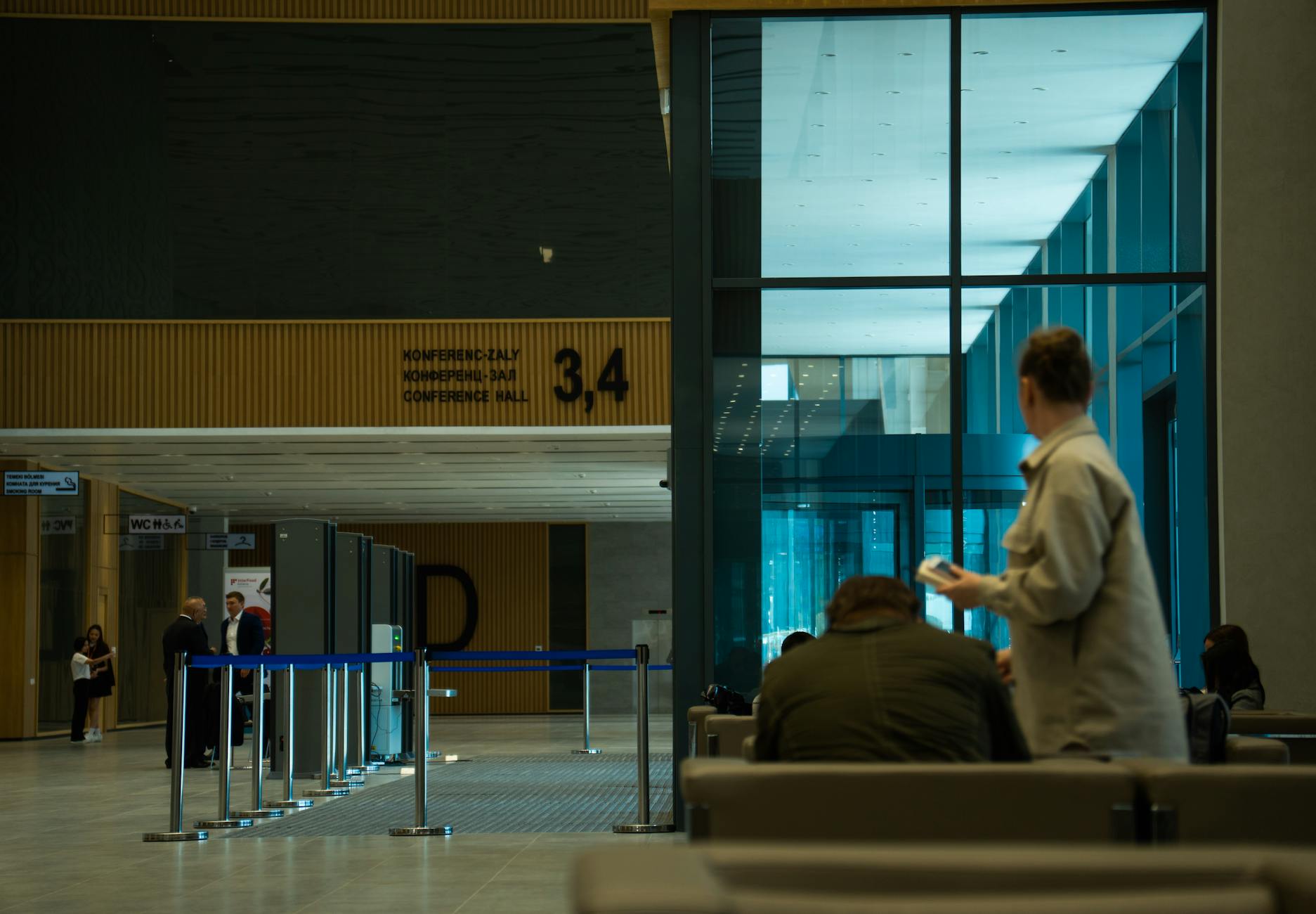 Modern conference hall lobby with people seated at tables