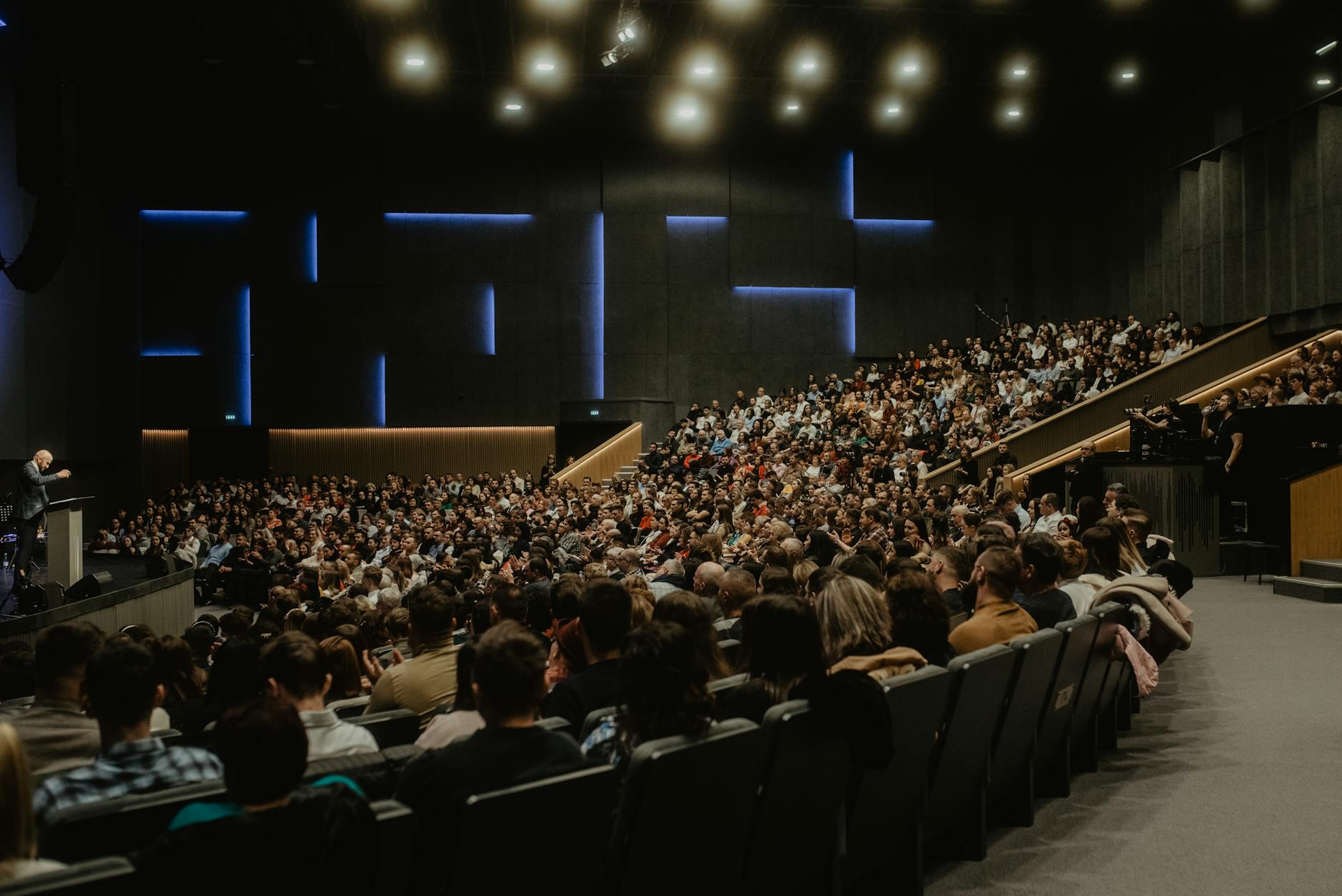 Large audience listening to a speaker at a conference