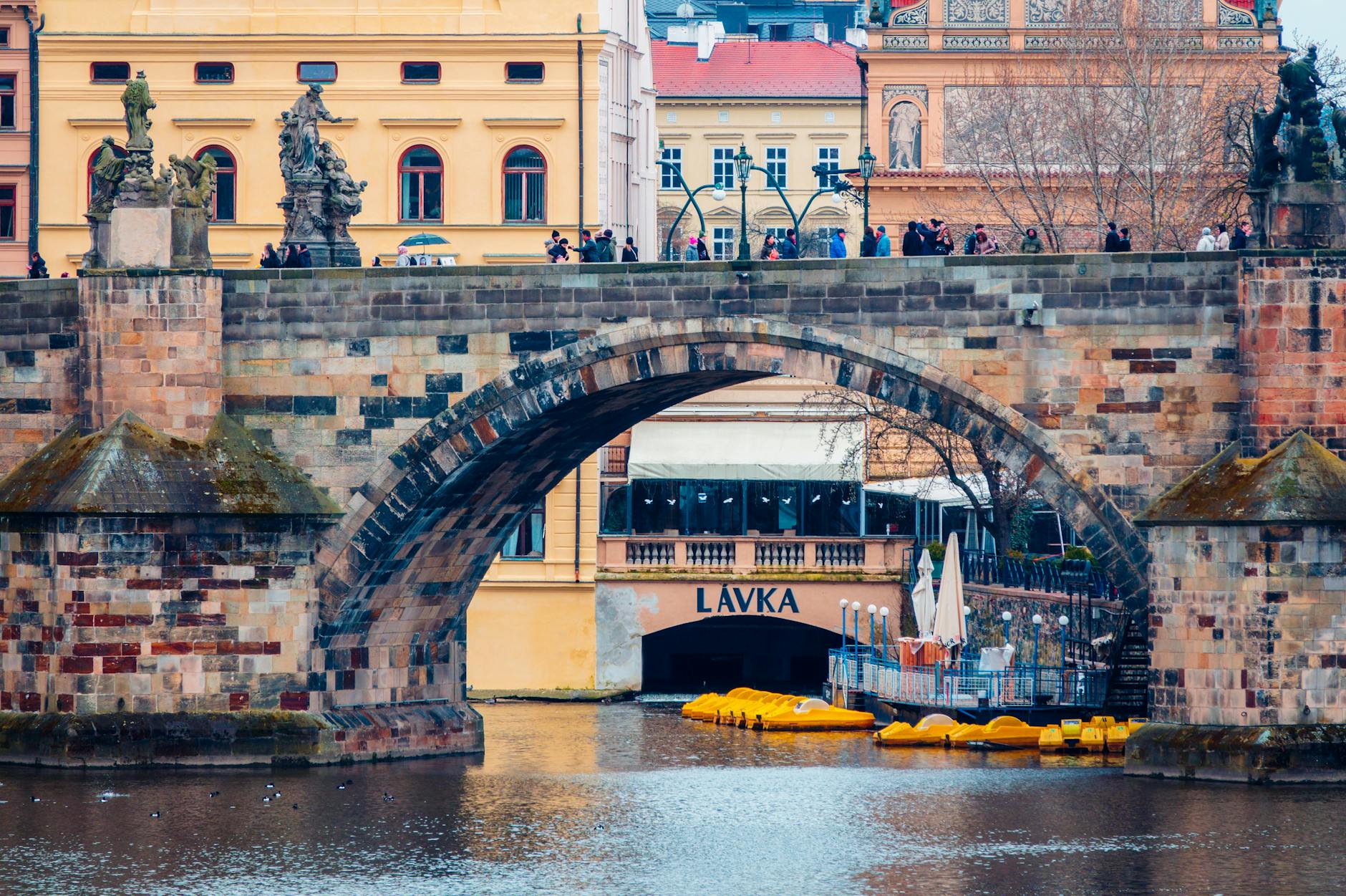 Charles Bridge with statues and Prague riverfront architecture