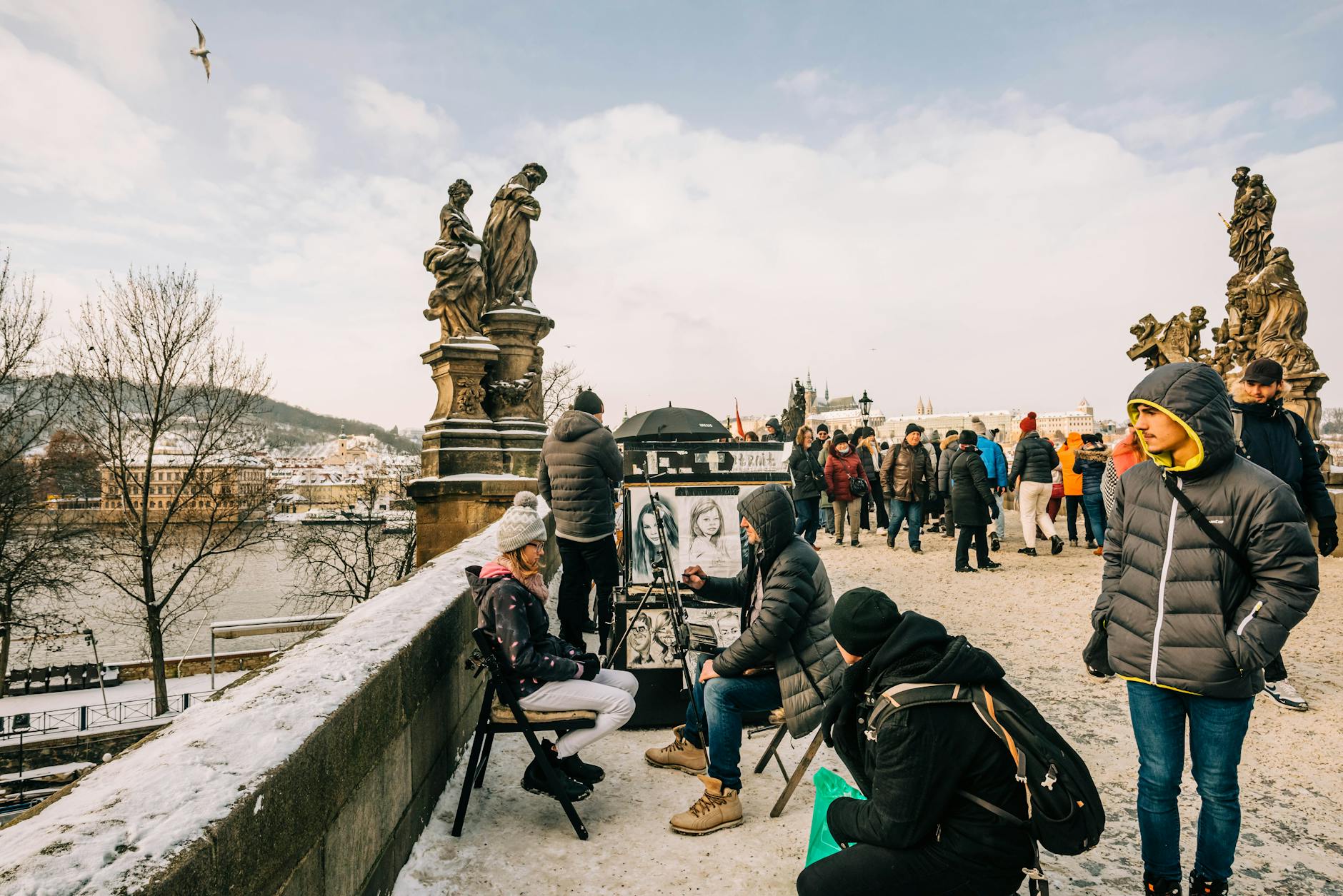 Street artists sketching portraits on Charles Bridge in winter