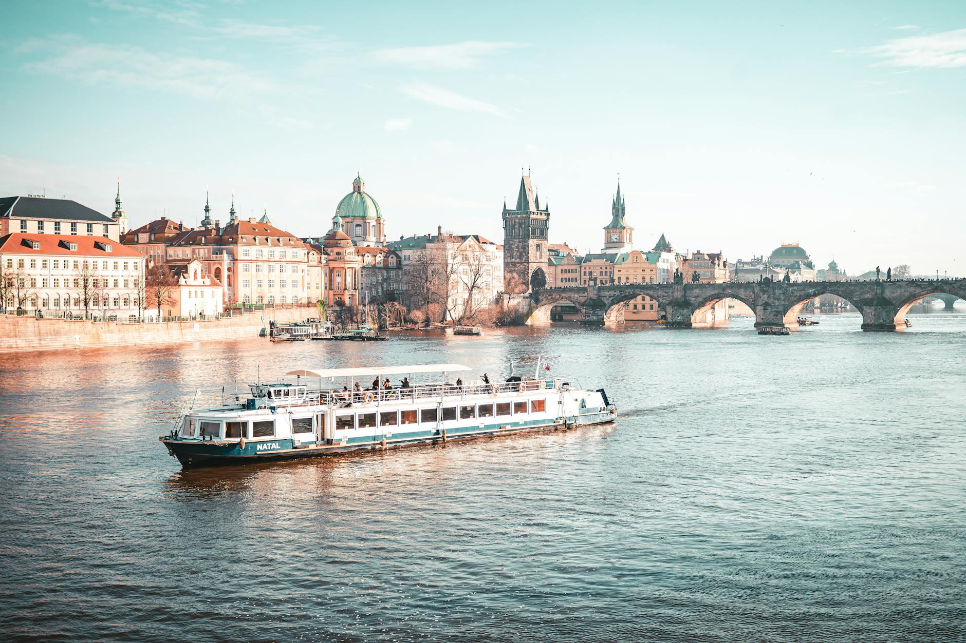 Boat cruising on the Vltava River near Charles Bridge