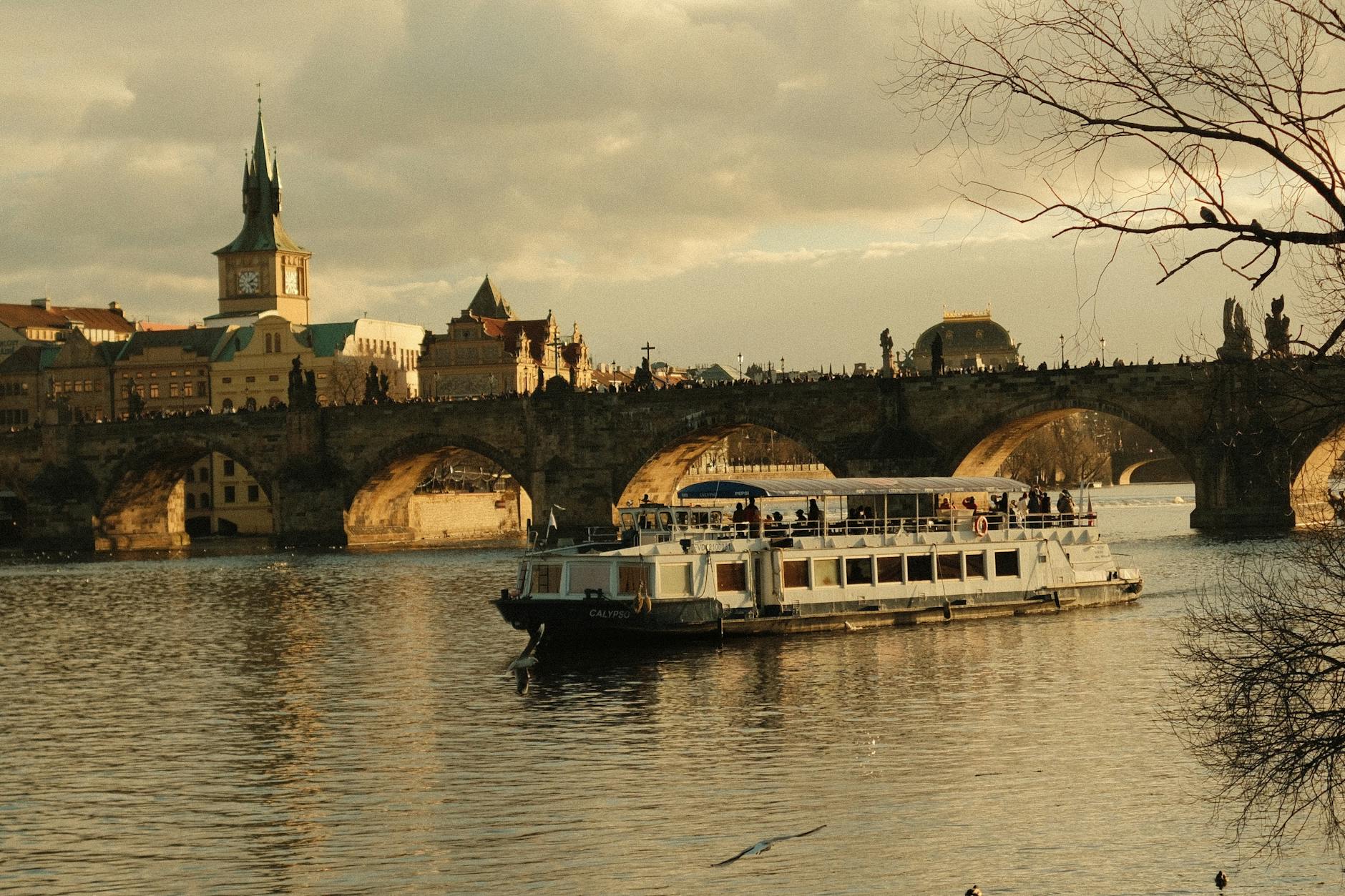 Cruise boat sailing under Charles Bridge on the Vltava River