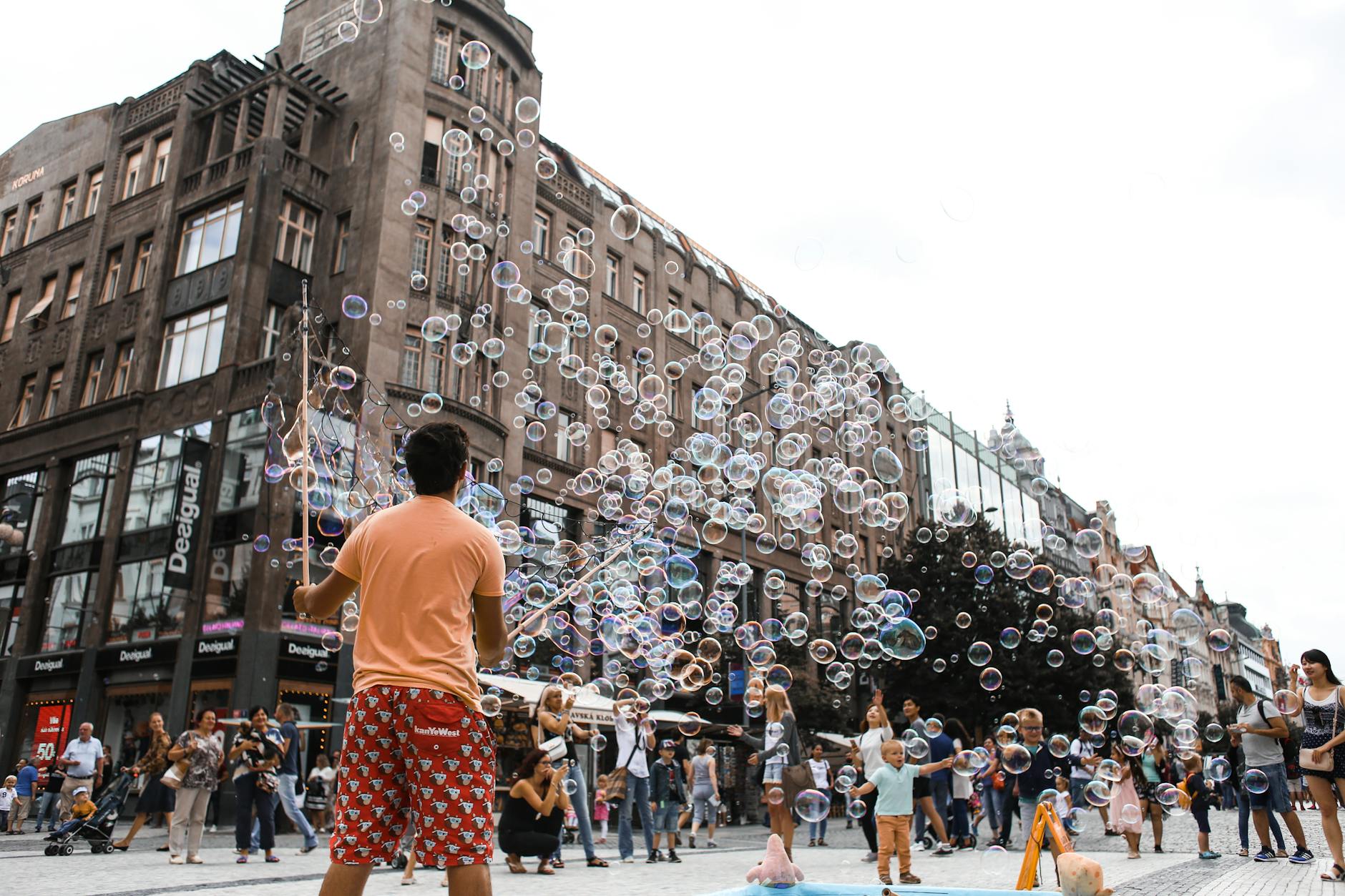 Street performer making bubbles for a crowd in a city square