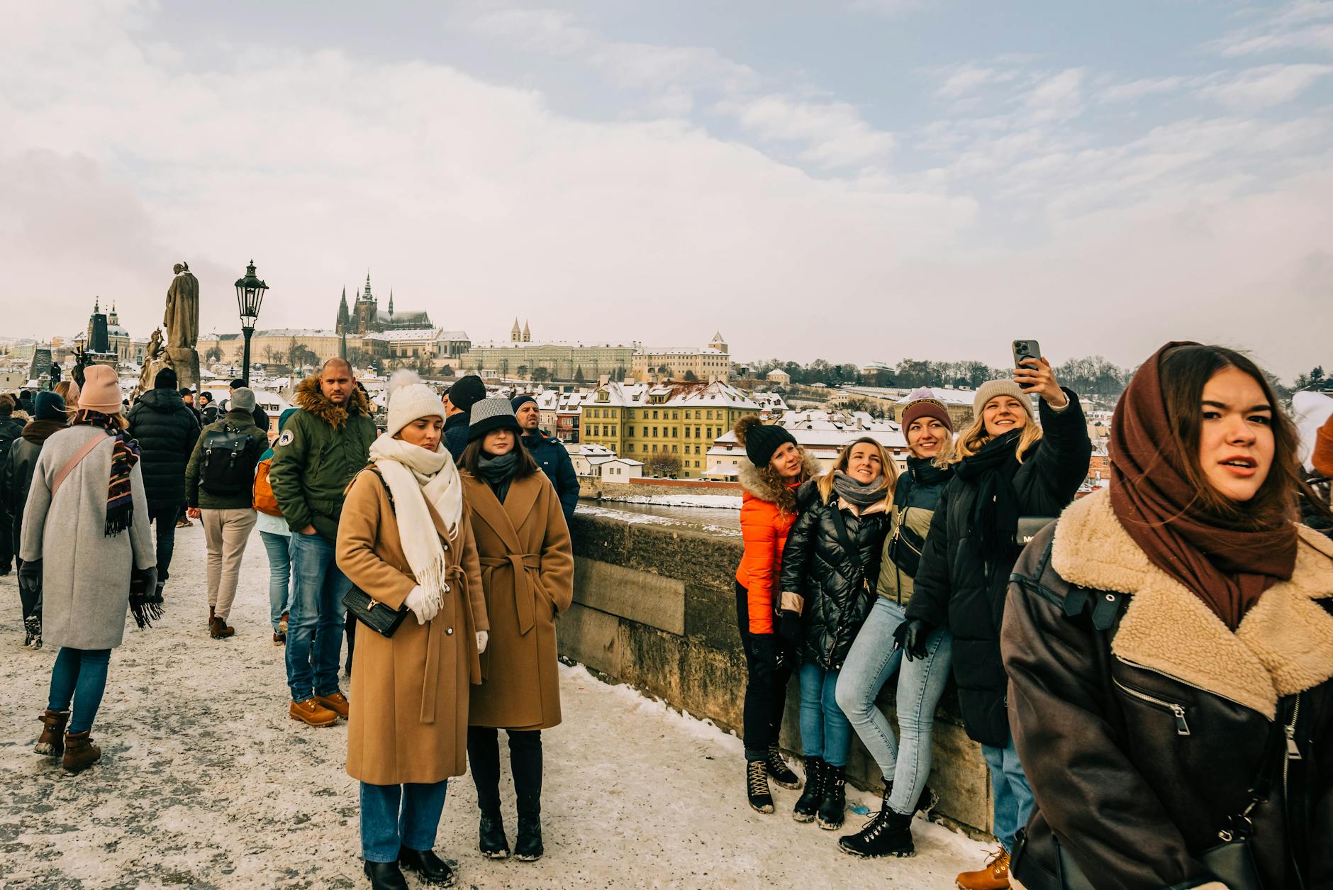 Tourists on Charles Bridge during a snowy Prague day
