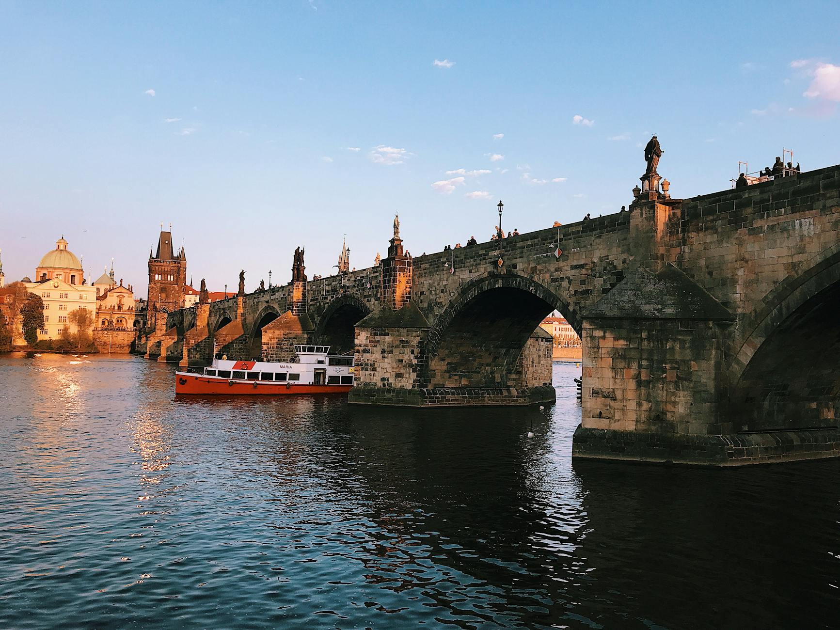 Charles Bridge and Prague landmarks at sunset over the Vltava River